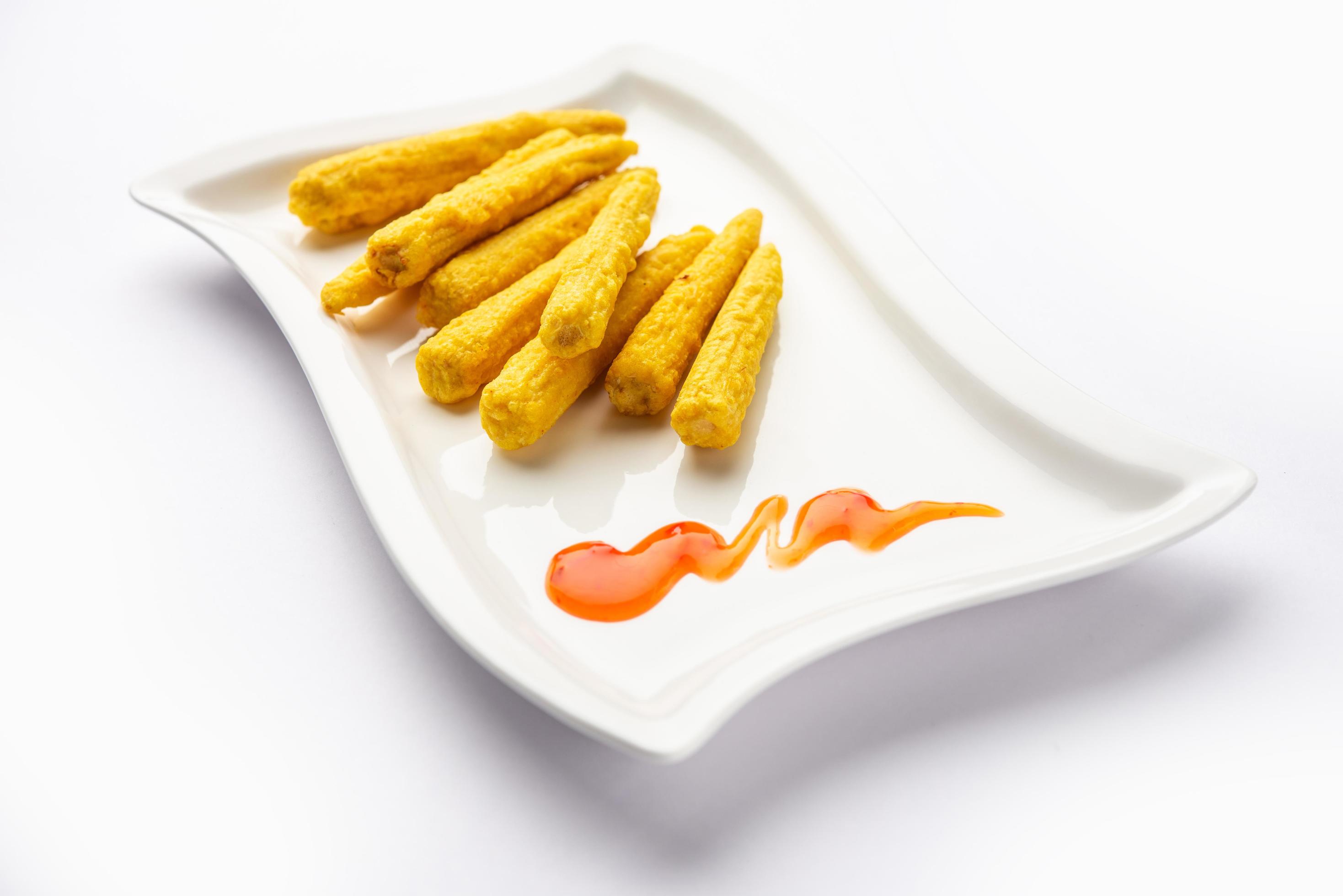 Crispy fried baby corn pakoda, pakora or Baby corn fritters served with ketchup, Indian food Stock Free