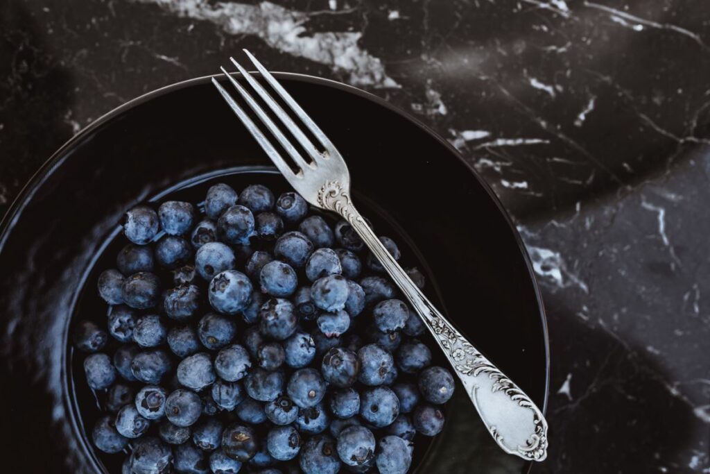 Fresh blueberries on a black plate with vintage cutlery Stock Free