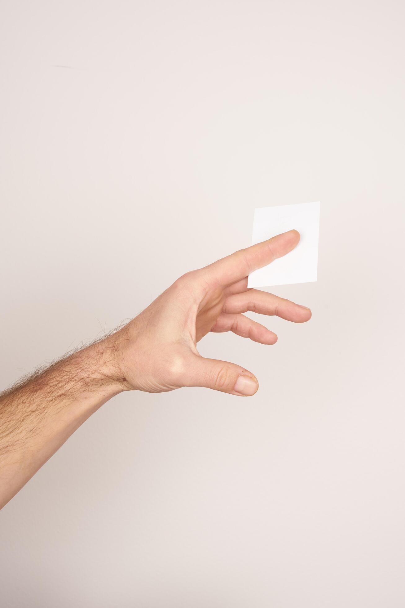 Male hand holding and giving a white blank business card Stock Free