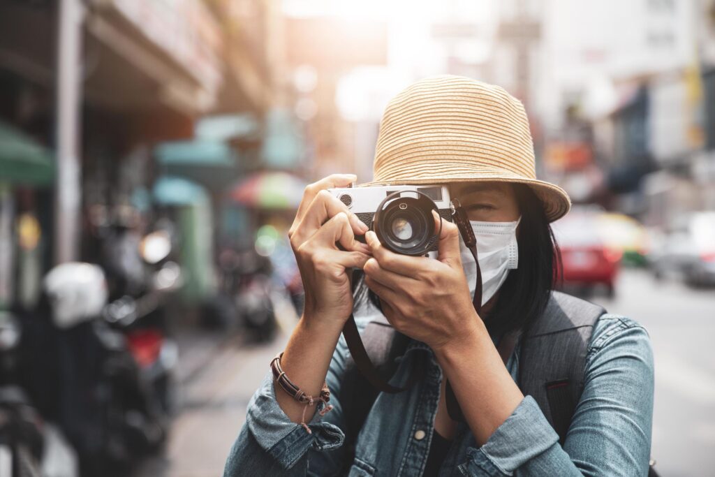 Asian women wearing surgical face mask traveler with camera travel of lifestyle portrait , outdoor summer concept Stock Free