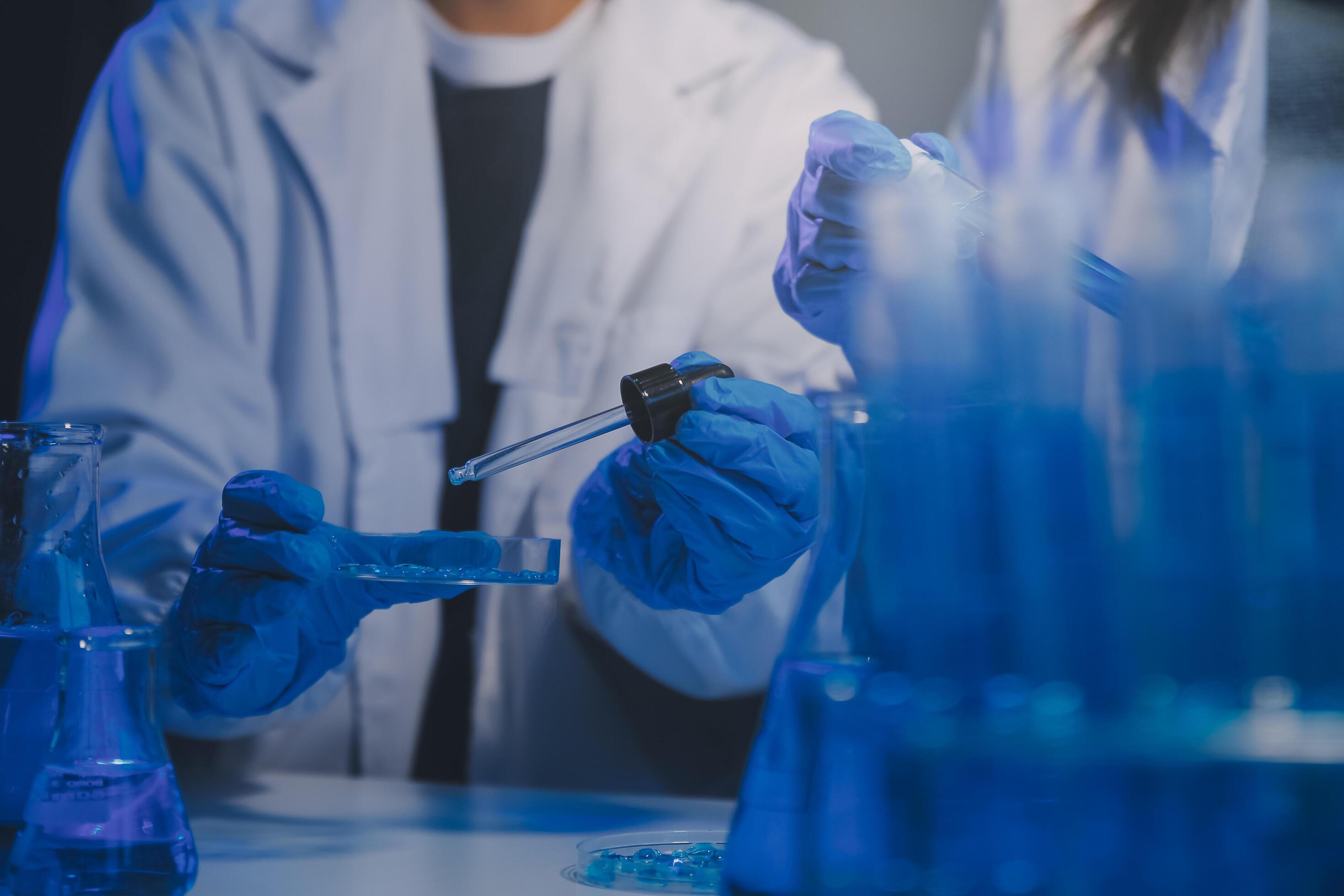 chemist,scientist hand dropping chemical liquid into test tube, science research and development concept Stock Free