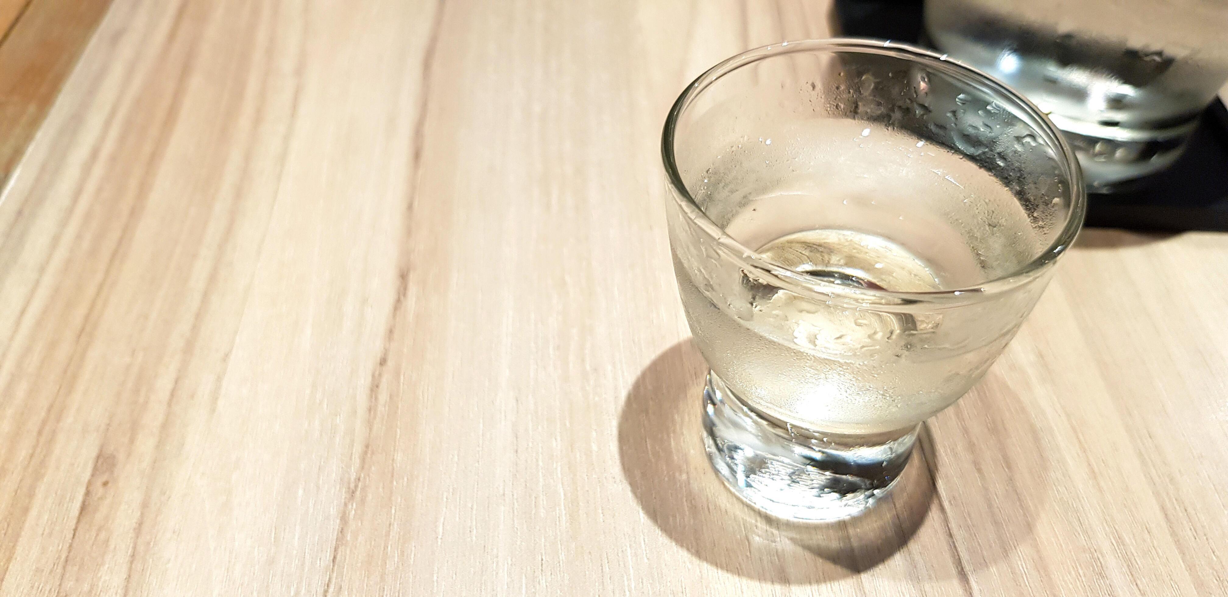 Glass of cold water on the wooden table with copy space. Refreshment drinking on woode background. Stock Free