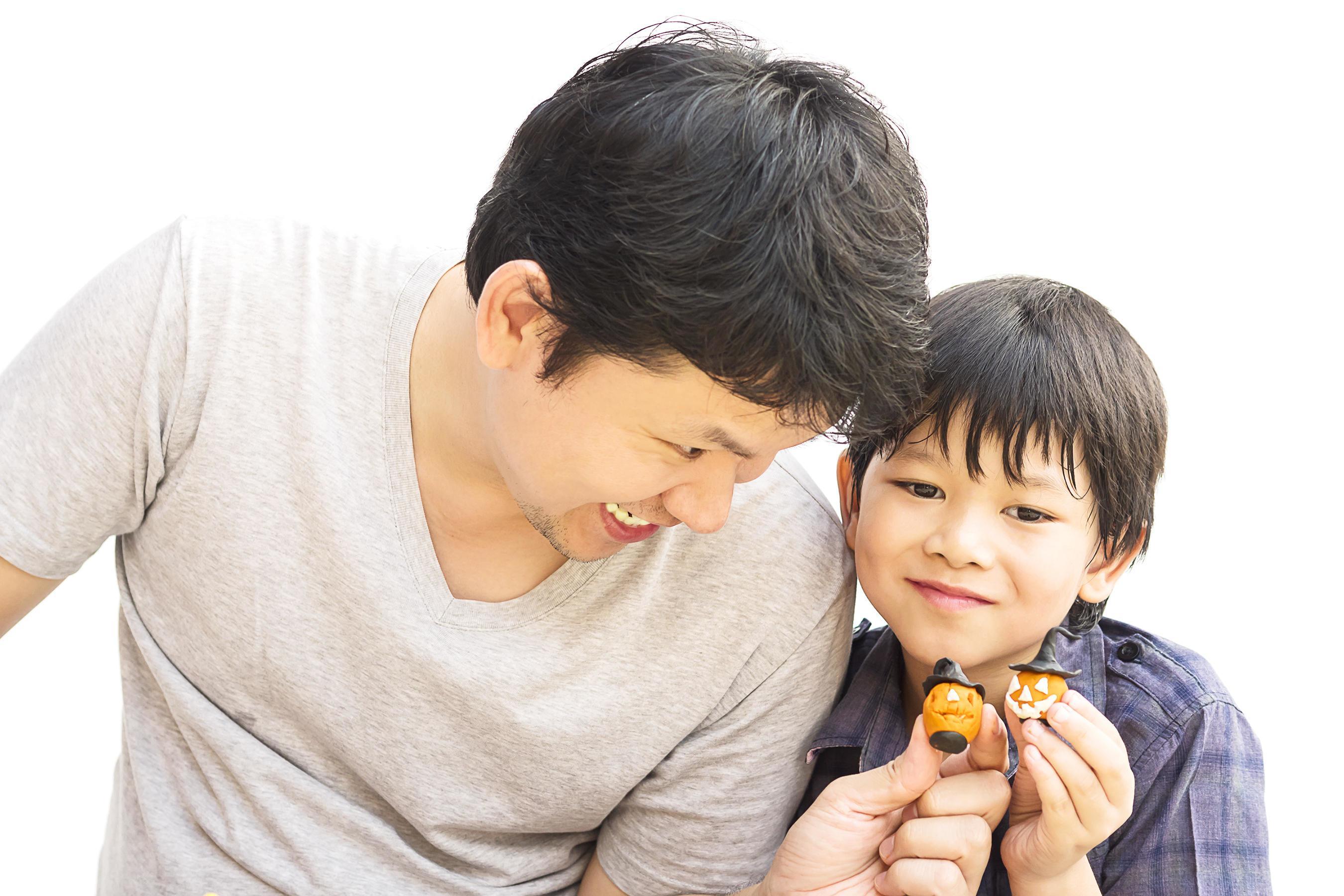 Father is playing Halloween clay with his son over white background Stock Free