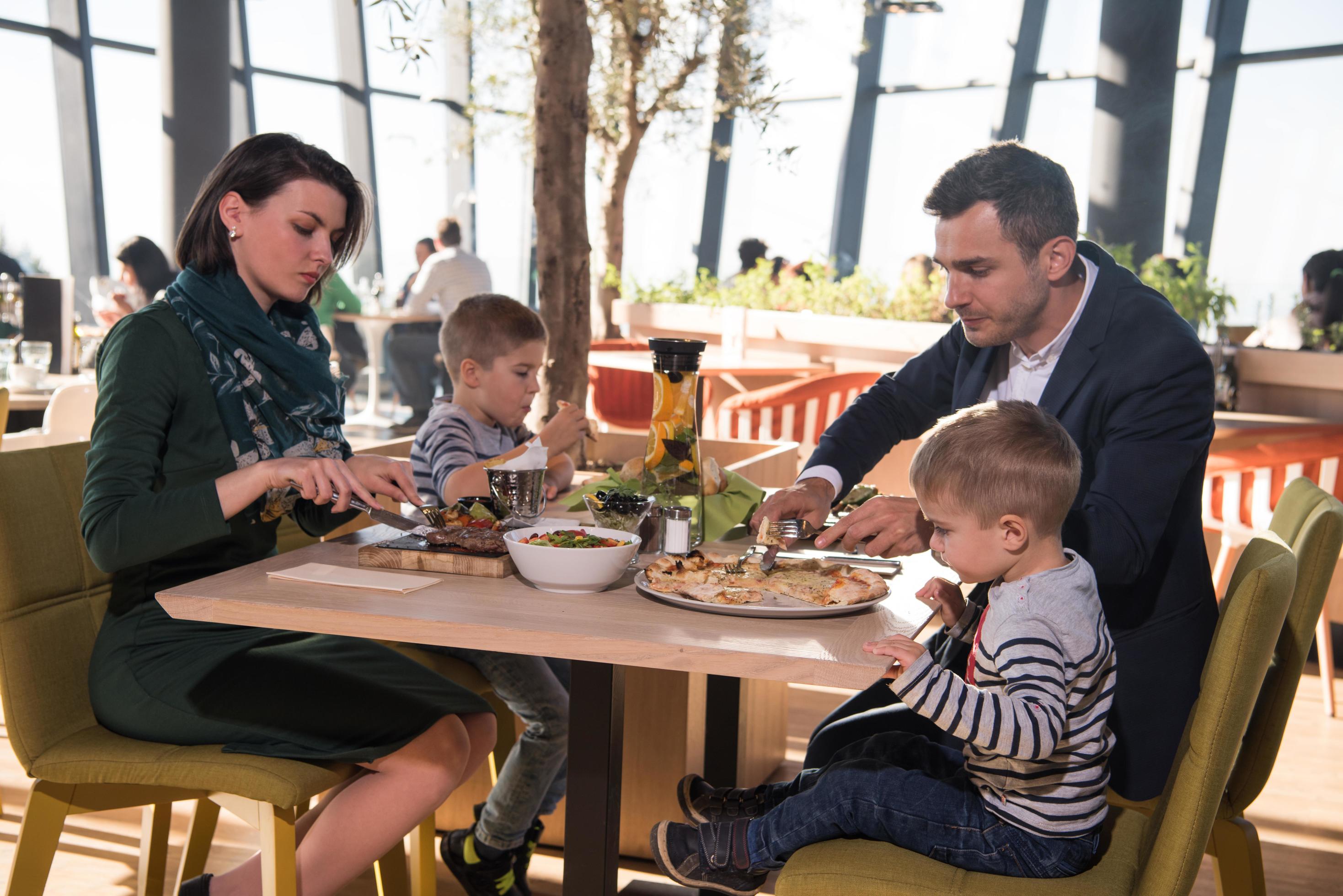 Young parents enjoying lunch time with their children Stock Free