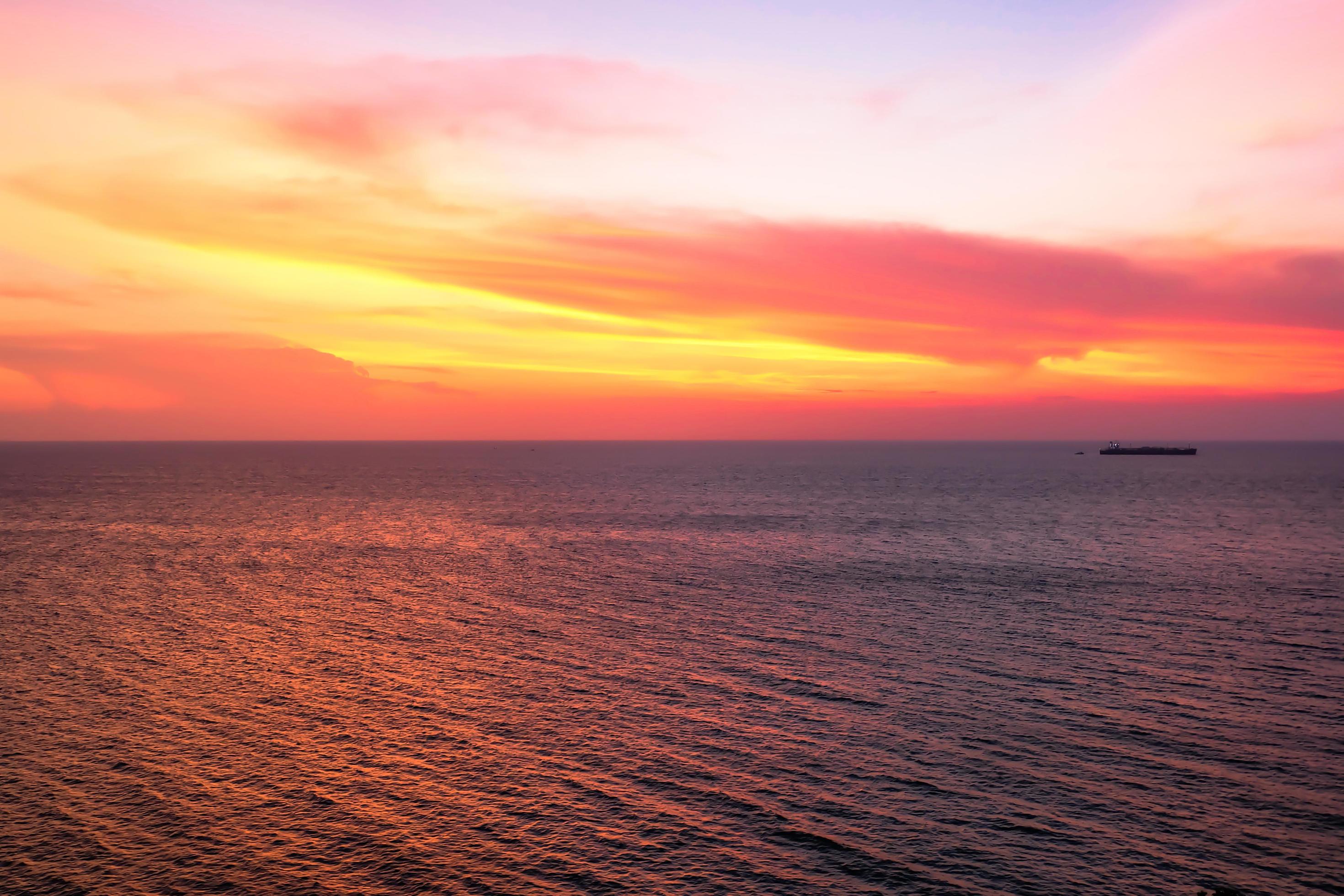 Colorfull sunset on the sea of Silhoutte Cargo Ship nature background Stock Free