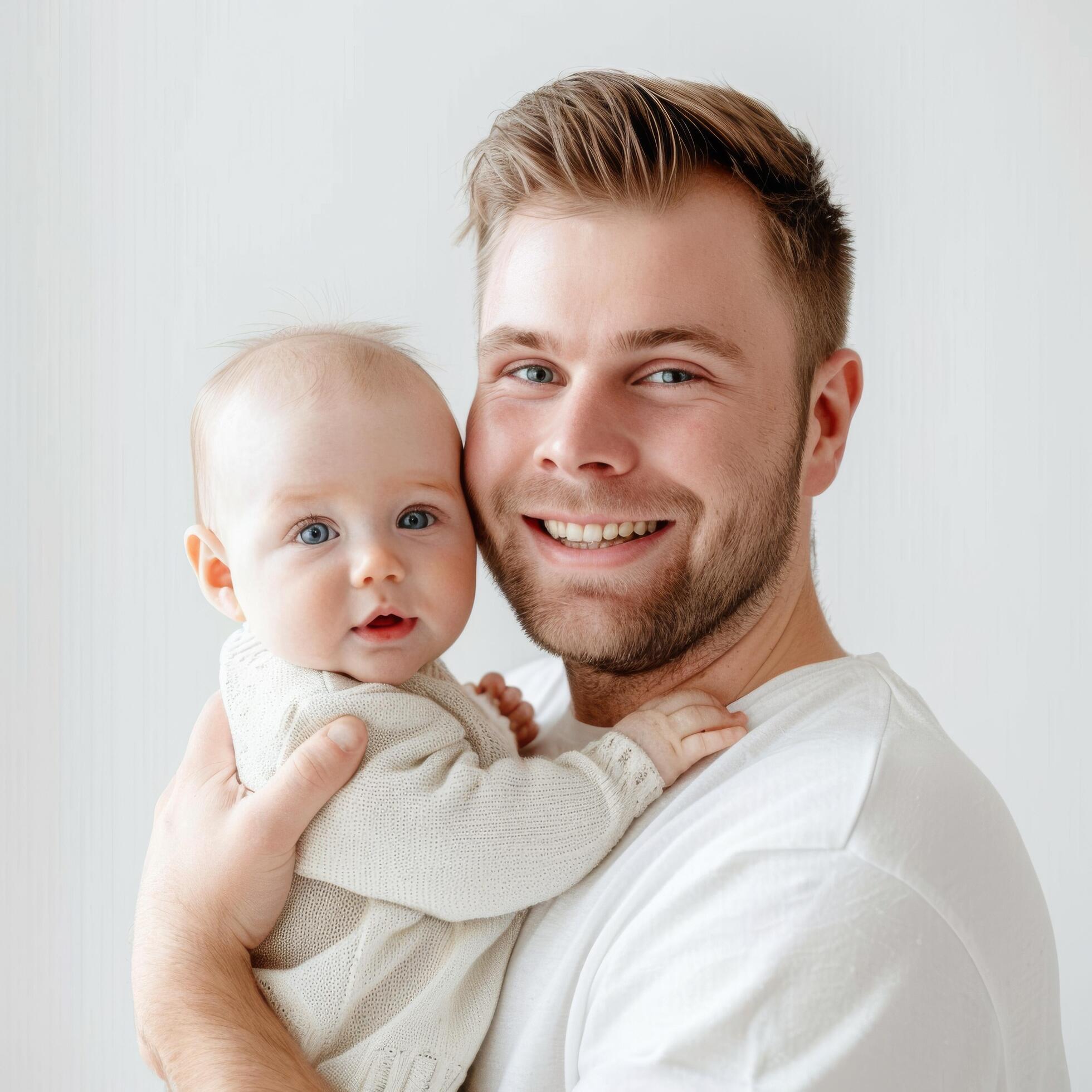 Smiling young father holding baby suitable for family services advertising Stock Free