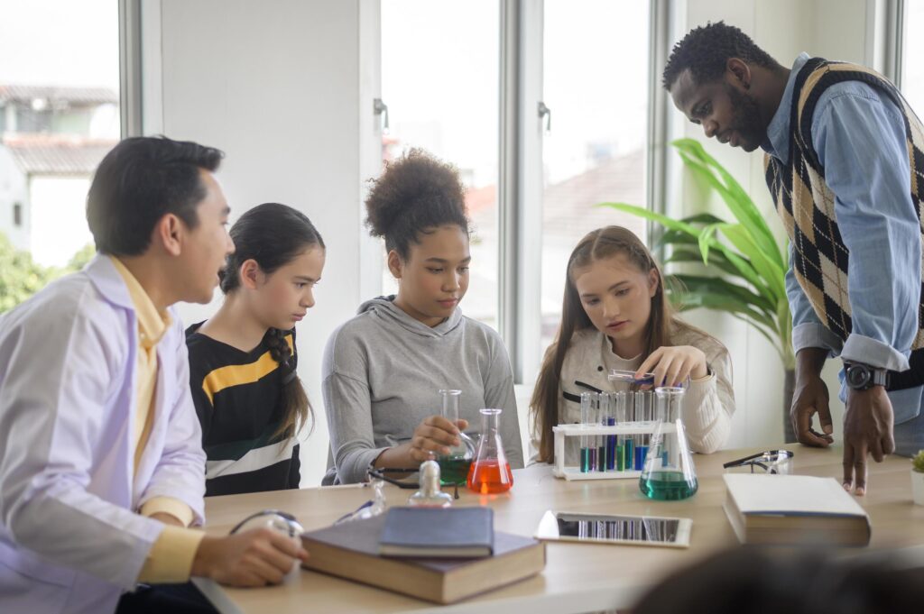 group of students studying and playing with teacher, education and learning concept. Stock Free