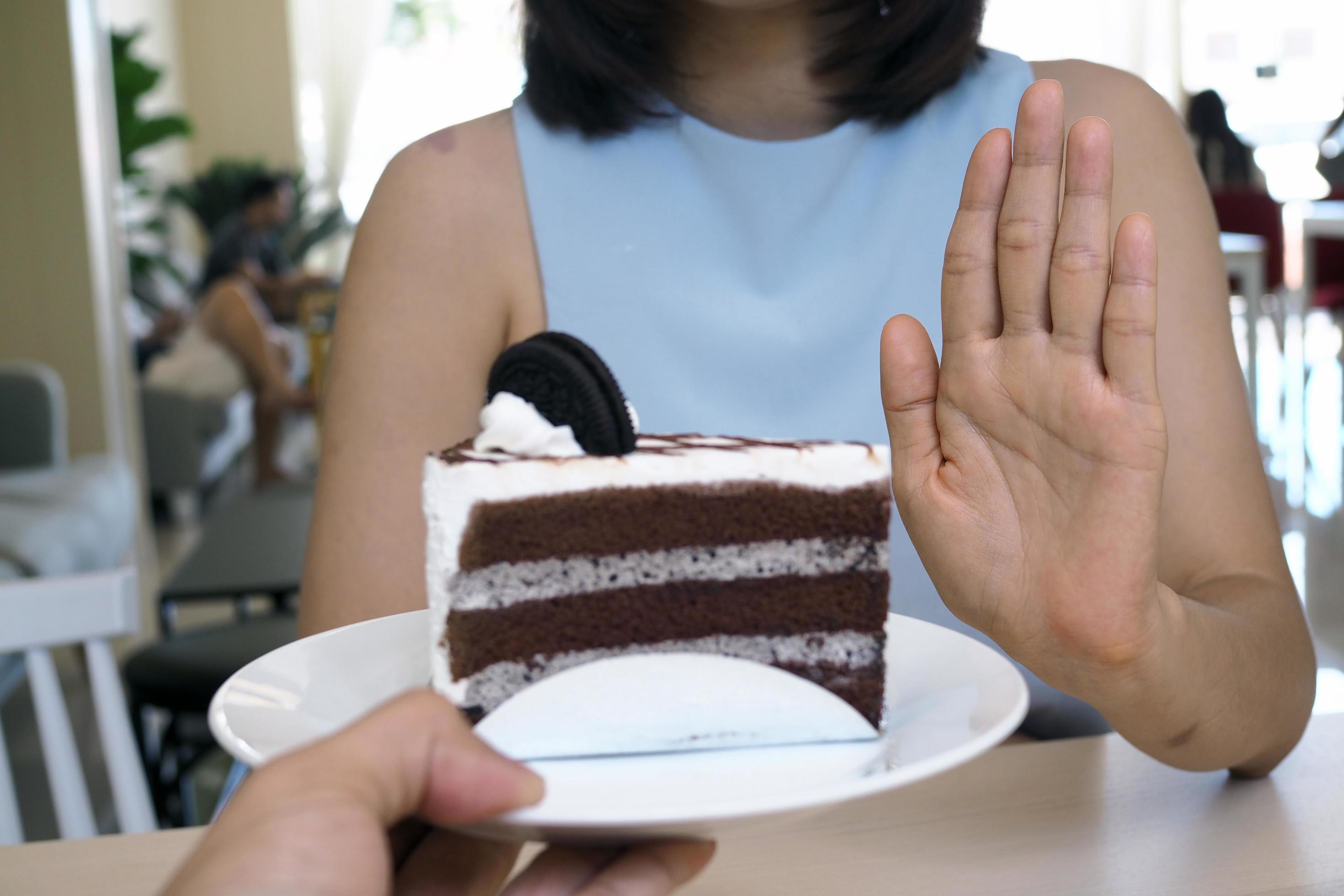 One of the health-care girls used a hand to push a plate of chocolate cake. Refuse to eat foods that contain Trans Fat. Stock Free