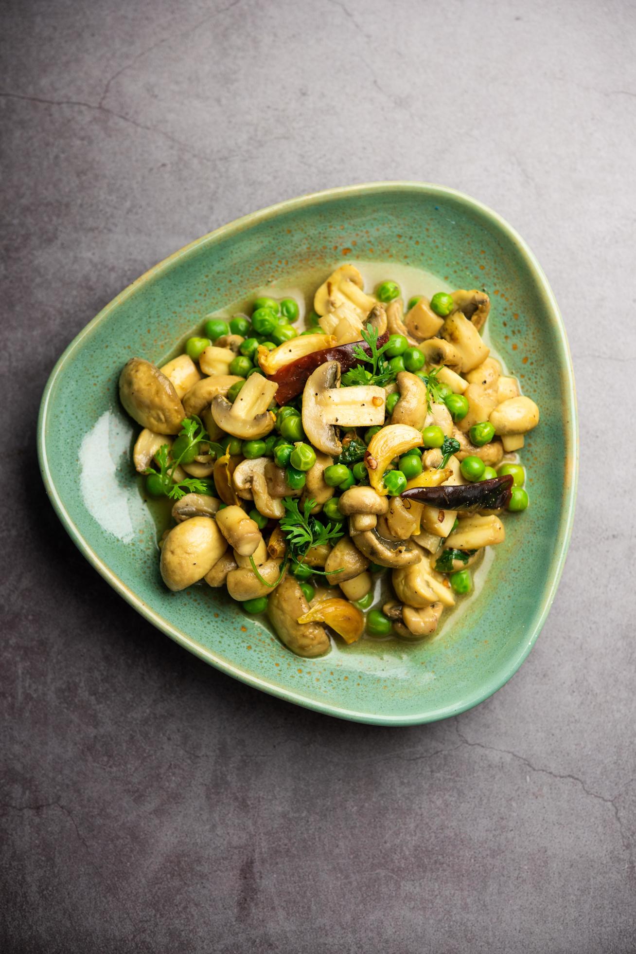 Mushroom and Pea Curry with Roasted Garlic, Indian food served in a bowl Stock Free