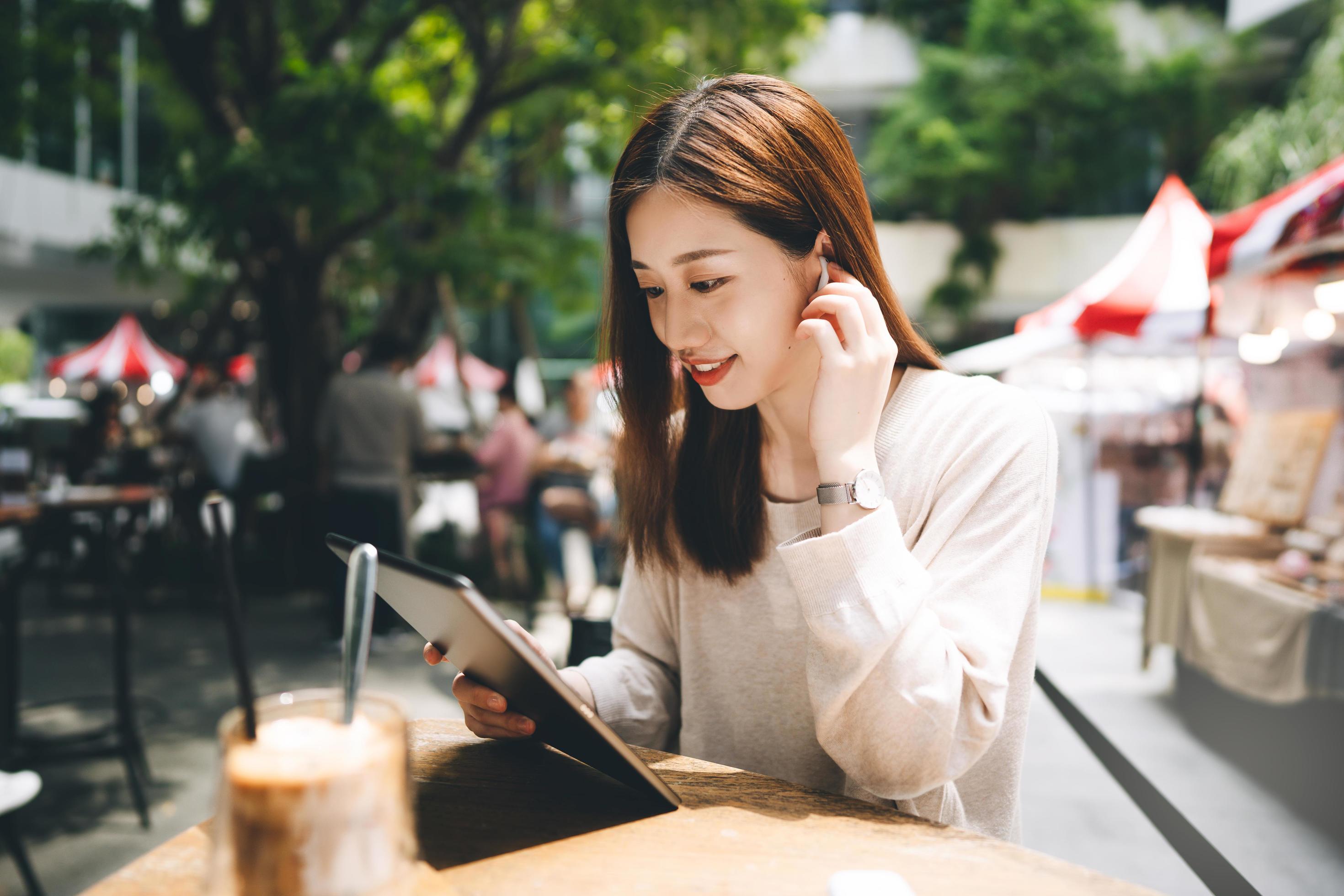 Young adult business asian woman use tablet for business at outdoor city lifestyle cafe. Stock Free