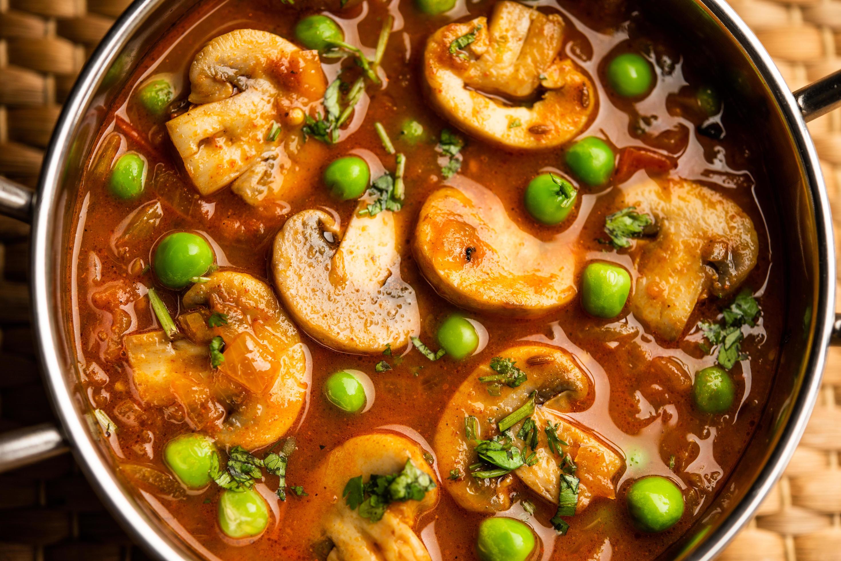 Mushroom and Pea Curry with Roasted Garlic, Indian food served in a bowl Stock Free