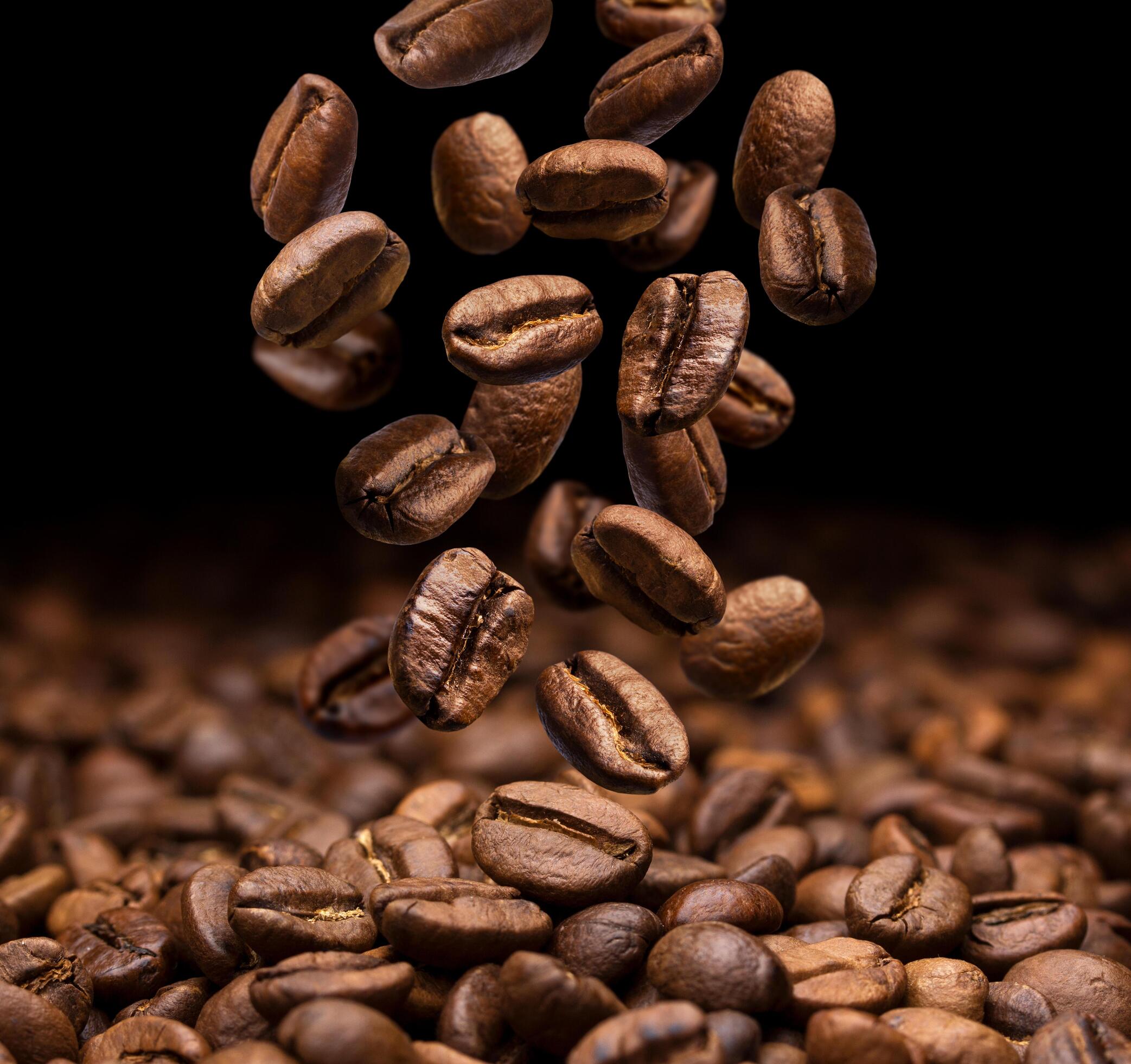 Falling coffee beans on dark background Stock Free