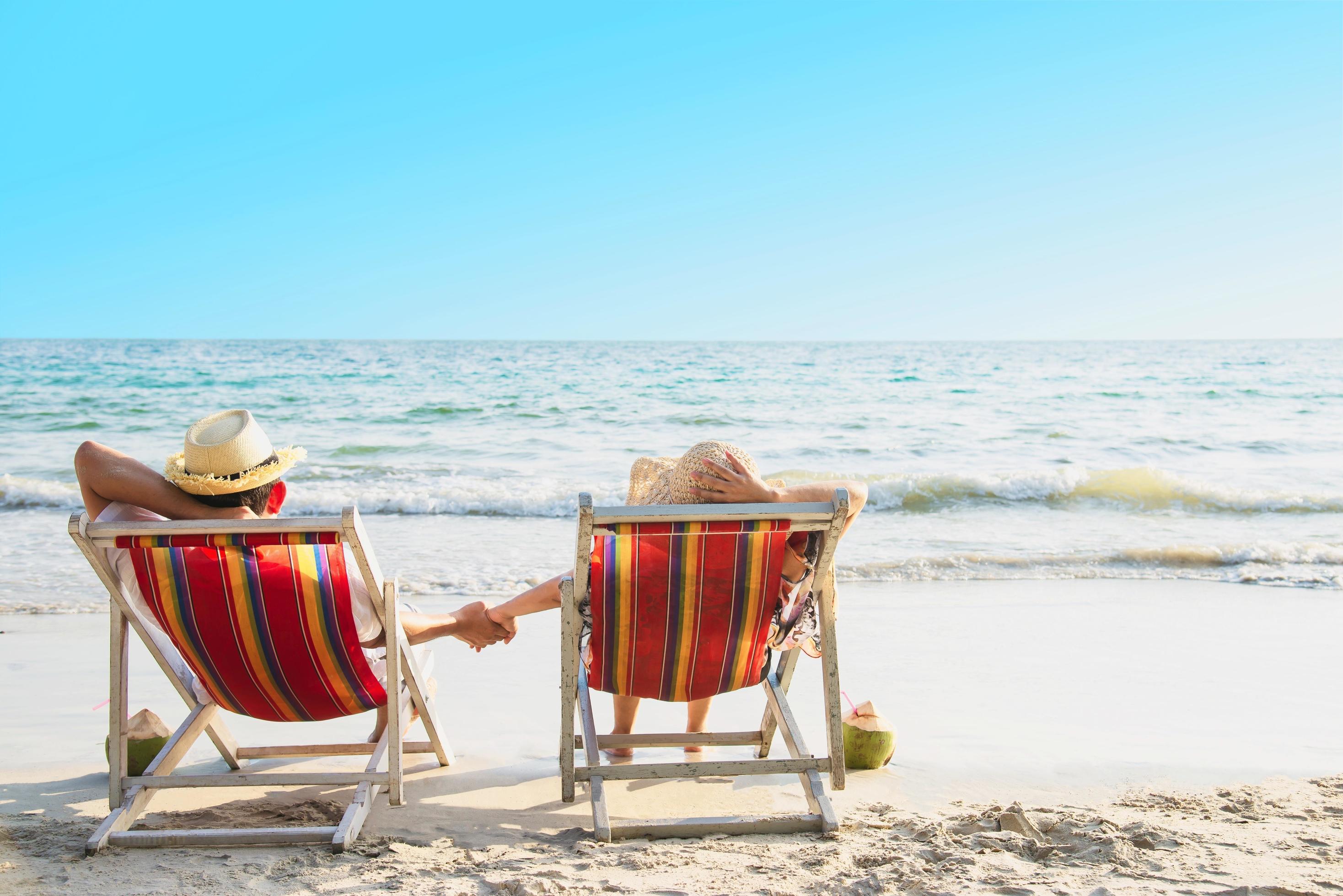 Relax couple lay down on beach chiar with sea wave background – man and woman have vacation at sea nature concept Stock Free