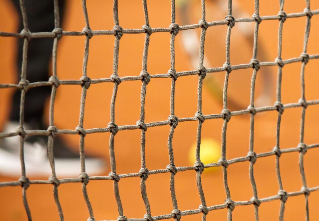 Tennis net on red clay closed tennis court Stock Free