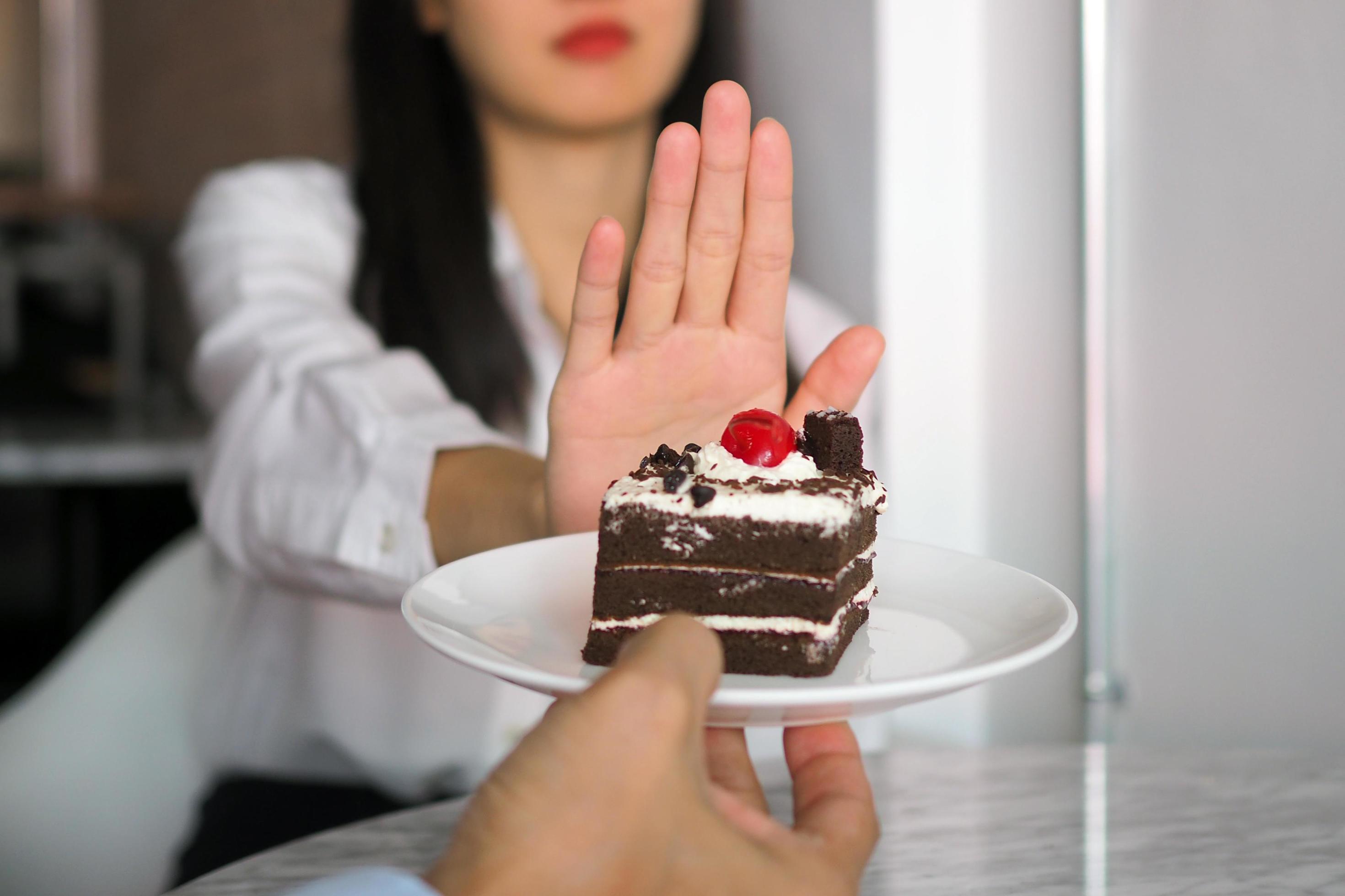 One of the health-care girls used a hand to push a plate of chocolate cake. Refuse to eat foods that contain Trans Fat. Stock Free