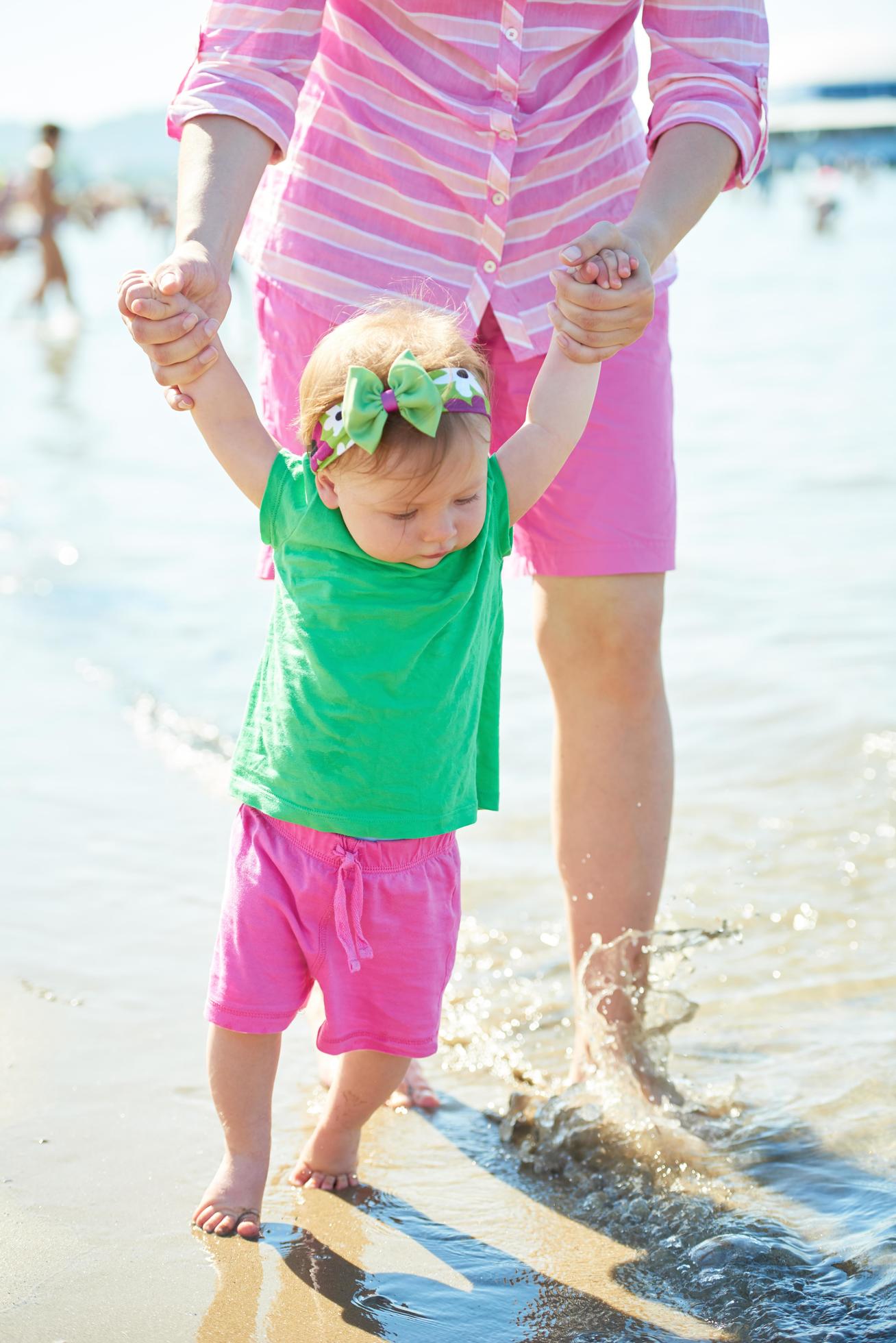 mom and baby on beach have fun Stock Free