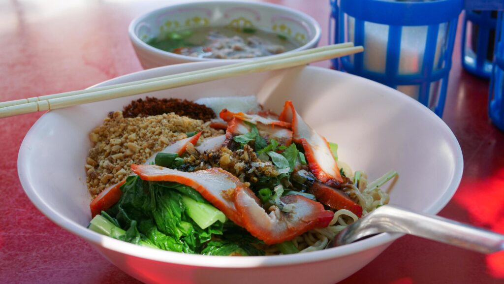 Dry red pork noodles. Yellow Noodles and Boiled Vegetables Topping with Roasted Pork. Famous Street Food in Thailand. Stock Free