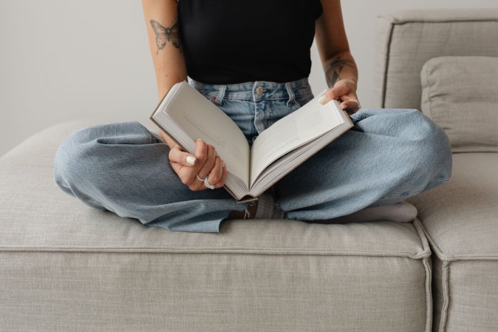 Woman in light-colored jeans with books Stock Free