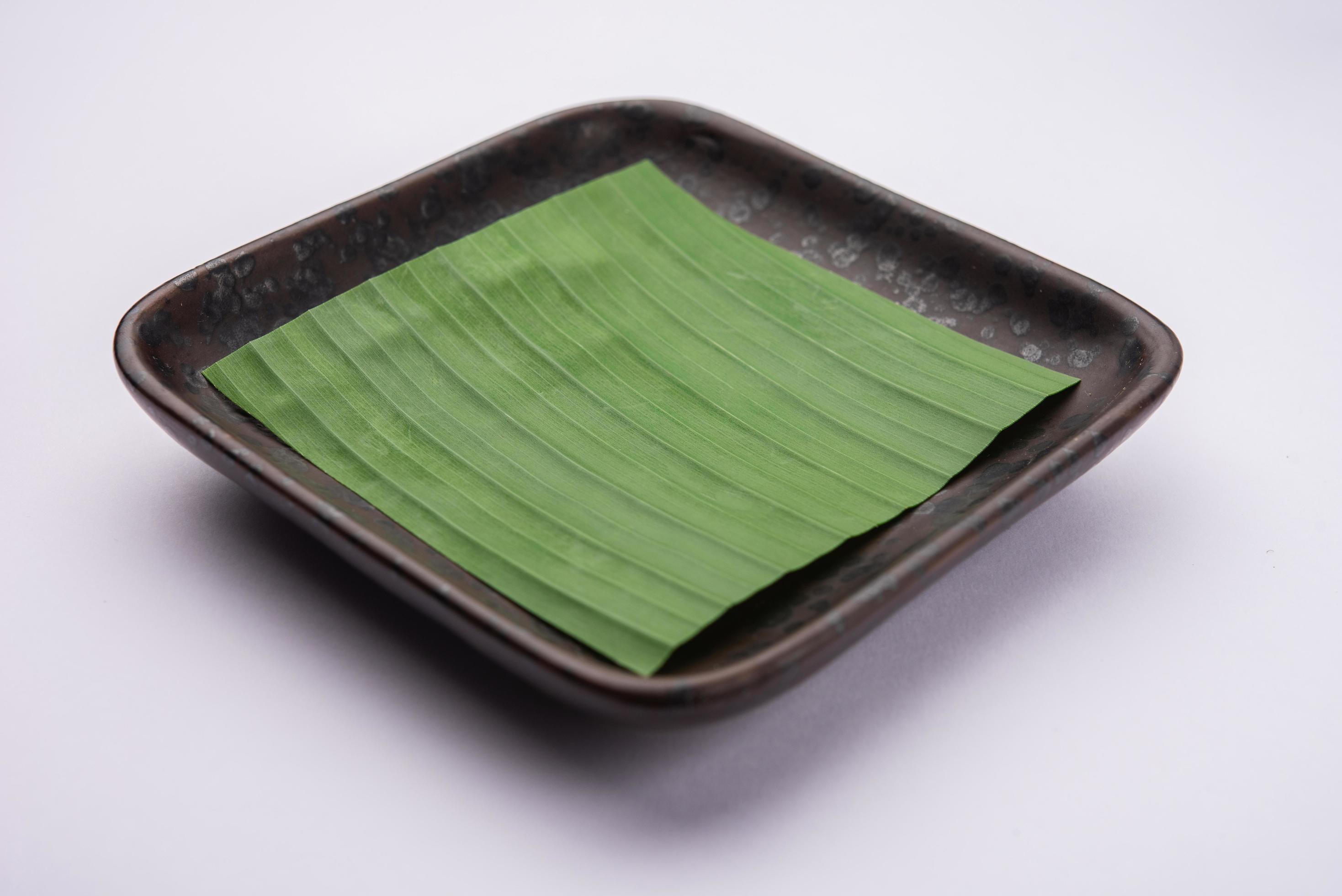 banana leaf on blank plate for edit food or subject on Stock Free