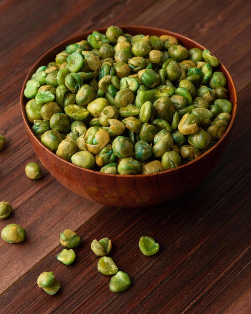 Salted green peas in wooden bowl on the table, Healthy snack, Vegetarian food Stock Free