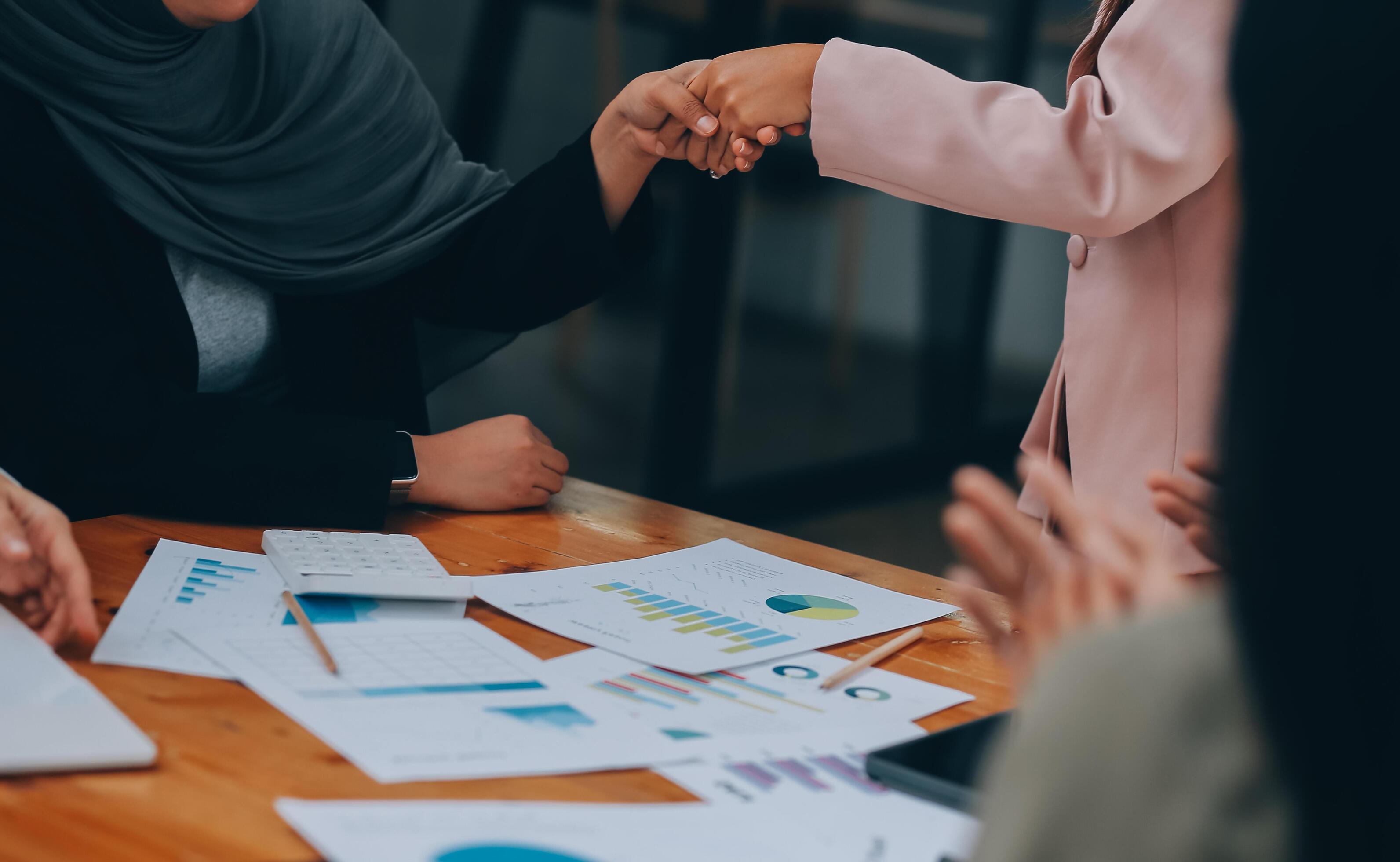 Businesswoman partnership handshake concept. Two young asian business professionals celebrating teamwork in an office, Colleague in meeting. Stock Free