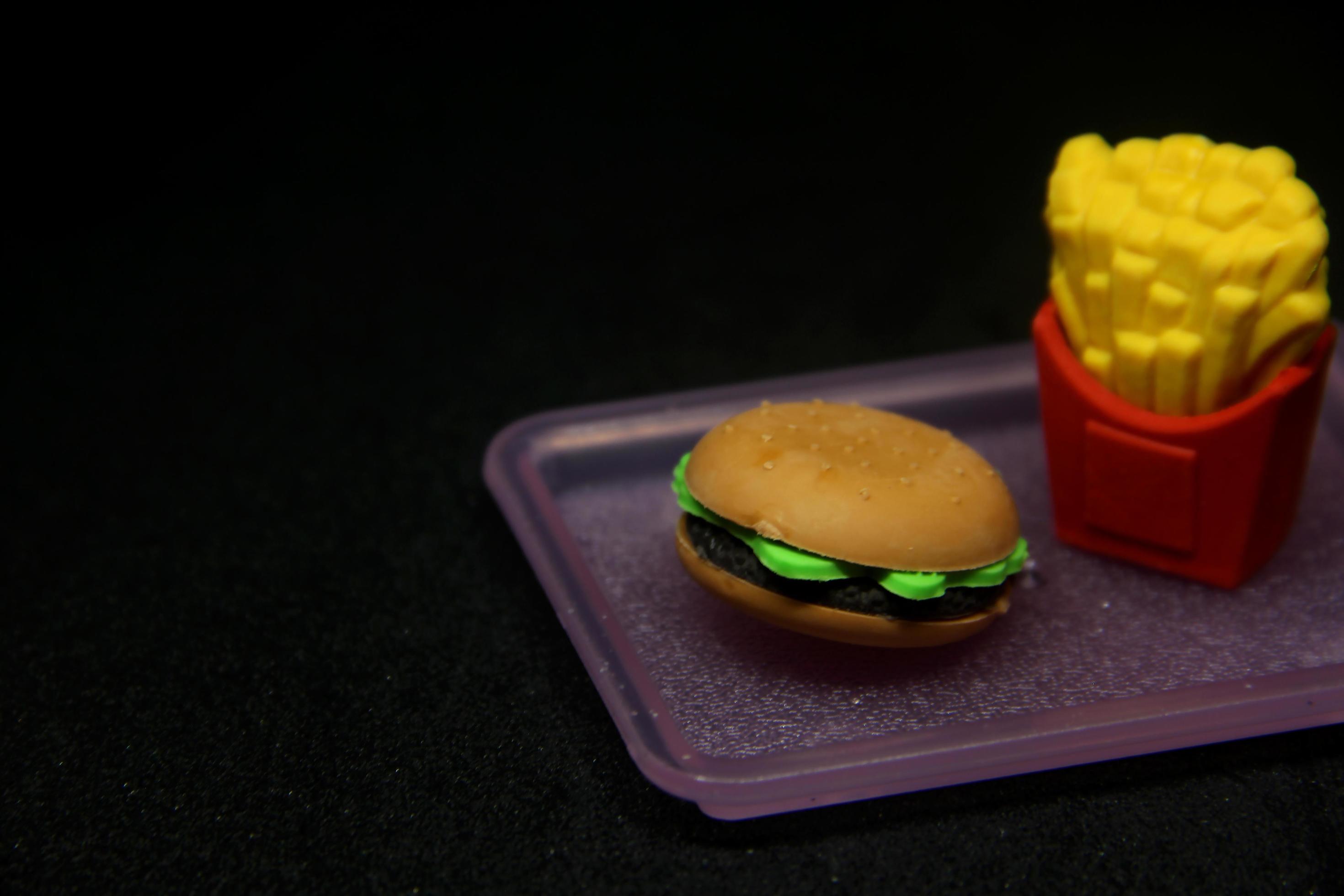 Hamburger and fries shaped eraser. School or office stationary tool supplies with junk food shape. isolated photo on dark black background. Stock Free