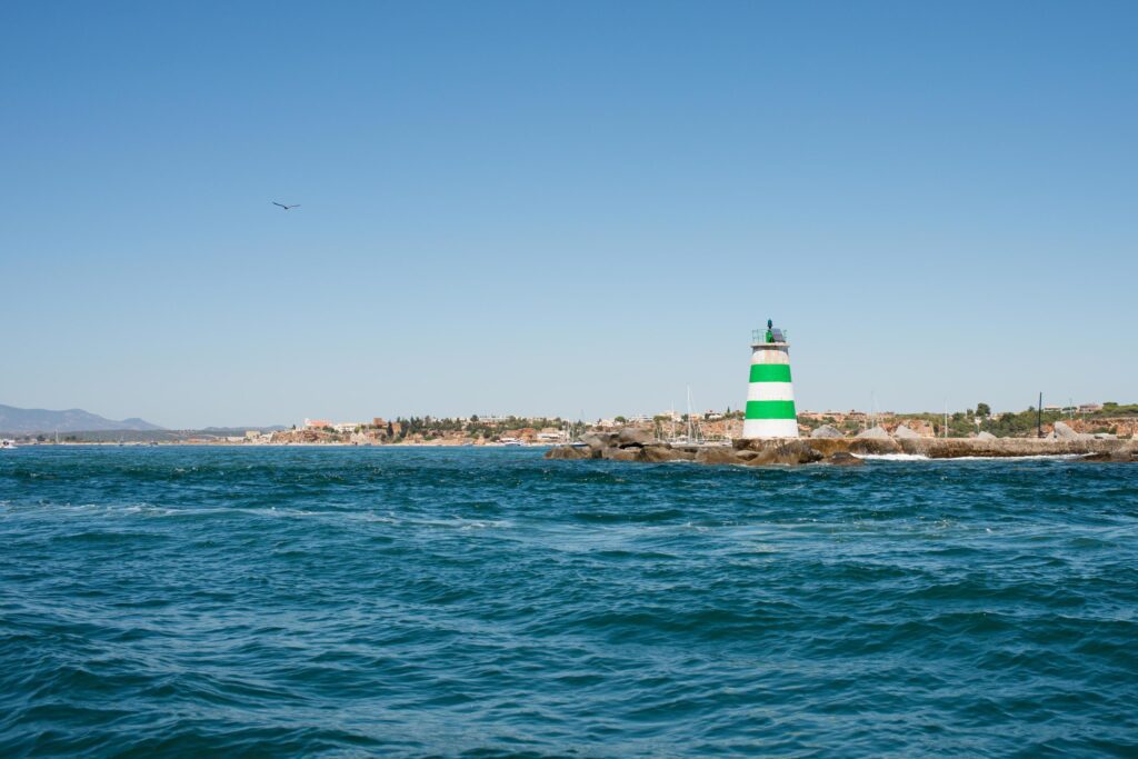 Beautiful atlantic coast near Portimao, Algarve. Lighthouse with green and white stripes. Portugal Stock Free