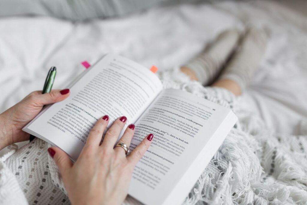 Soft photo of woman on the bed with the book and cup of coffee in hands Stock Free