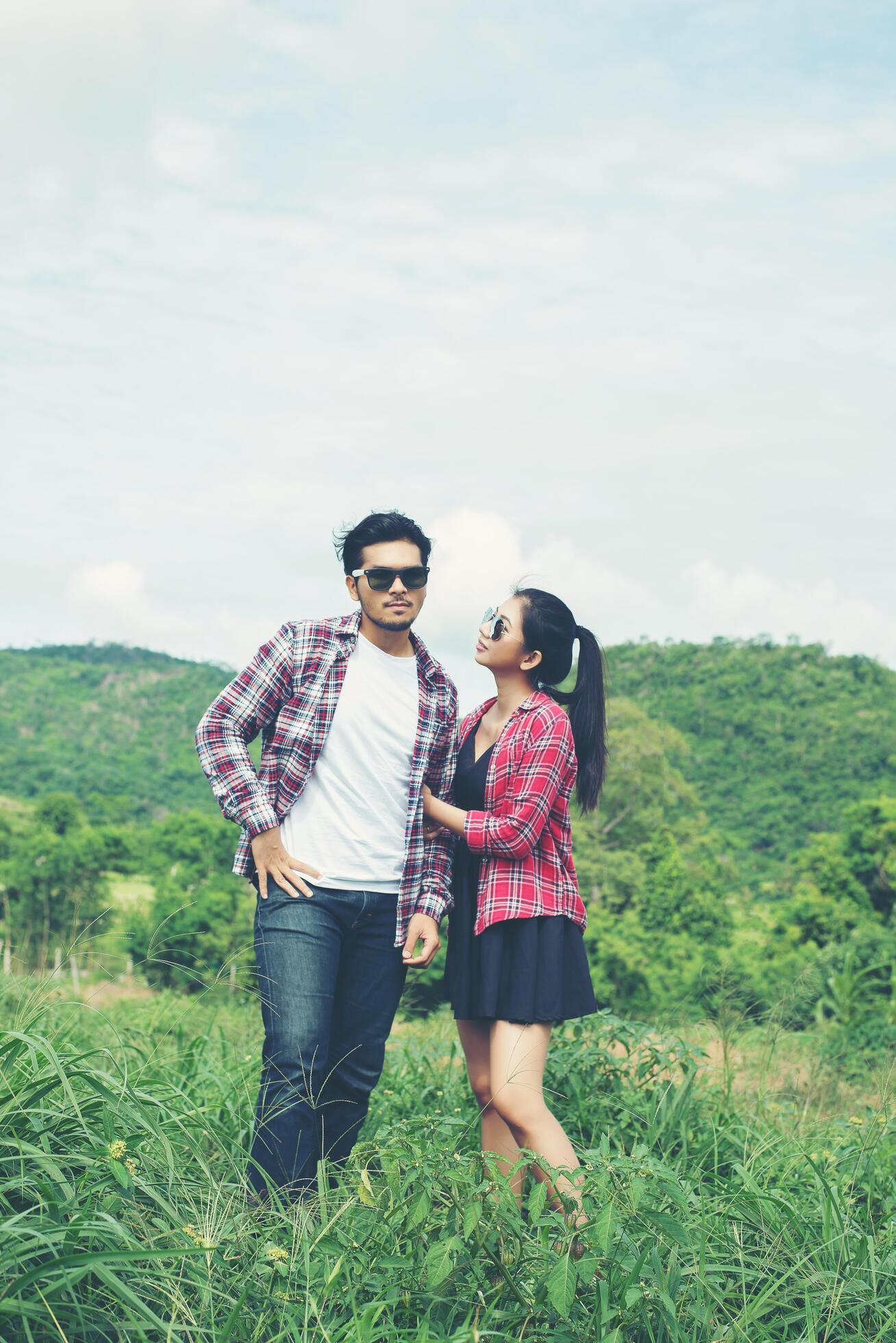 Young hipster couple holding hands walking on the meadow relaxing and natural atmosphere is very natural. Stock Free