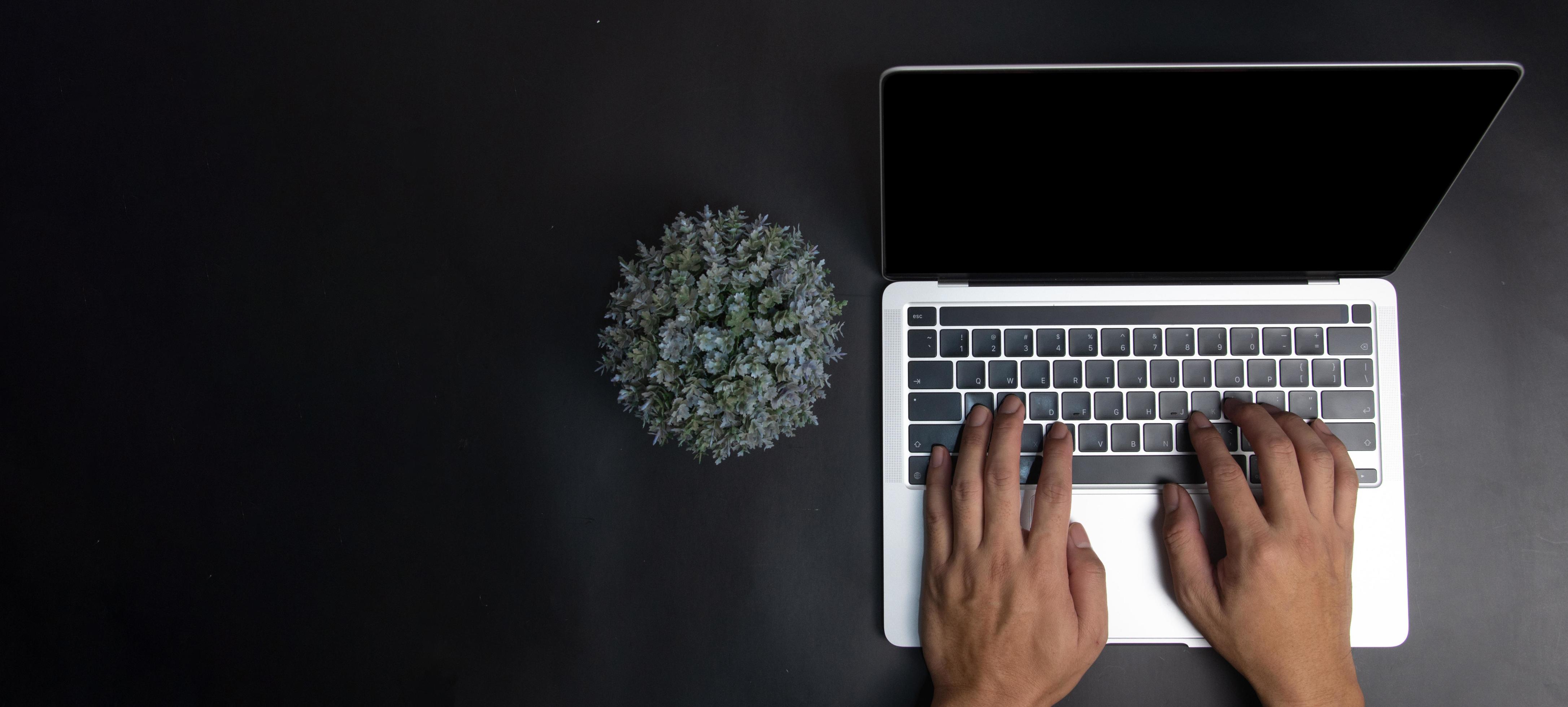 person using keyboard computer laptop digital technology top view on desk. Stock Free