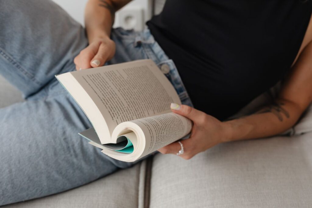 Woman in light-colored jeans with books Stock Free