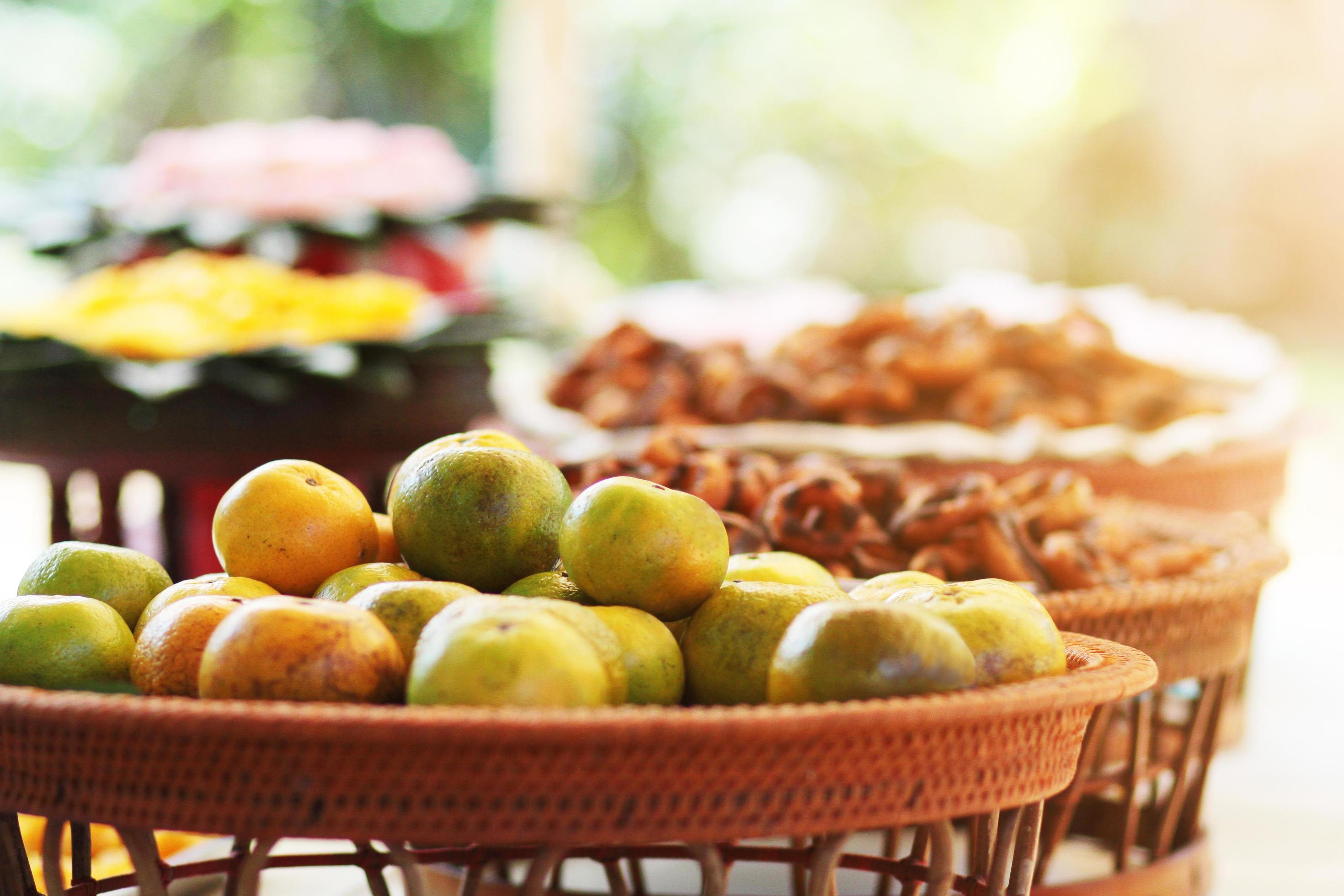 Fresh orange on banana leaves in wicker food tray. Thai buffet food tradition in event and wedding ceremony Stock Free