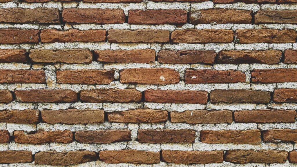 
									Brick wall with cement mortar close-up. Stock Free