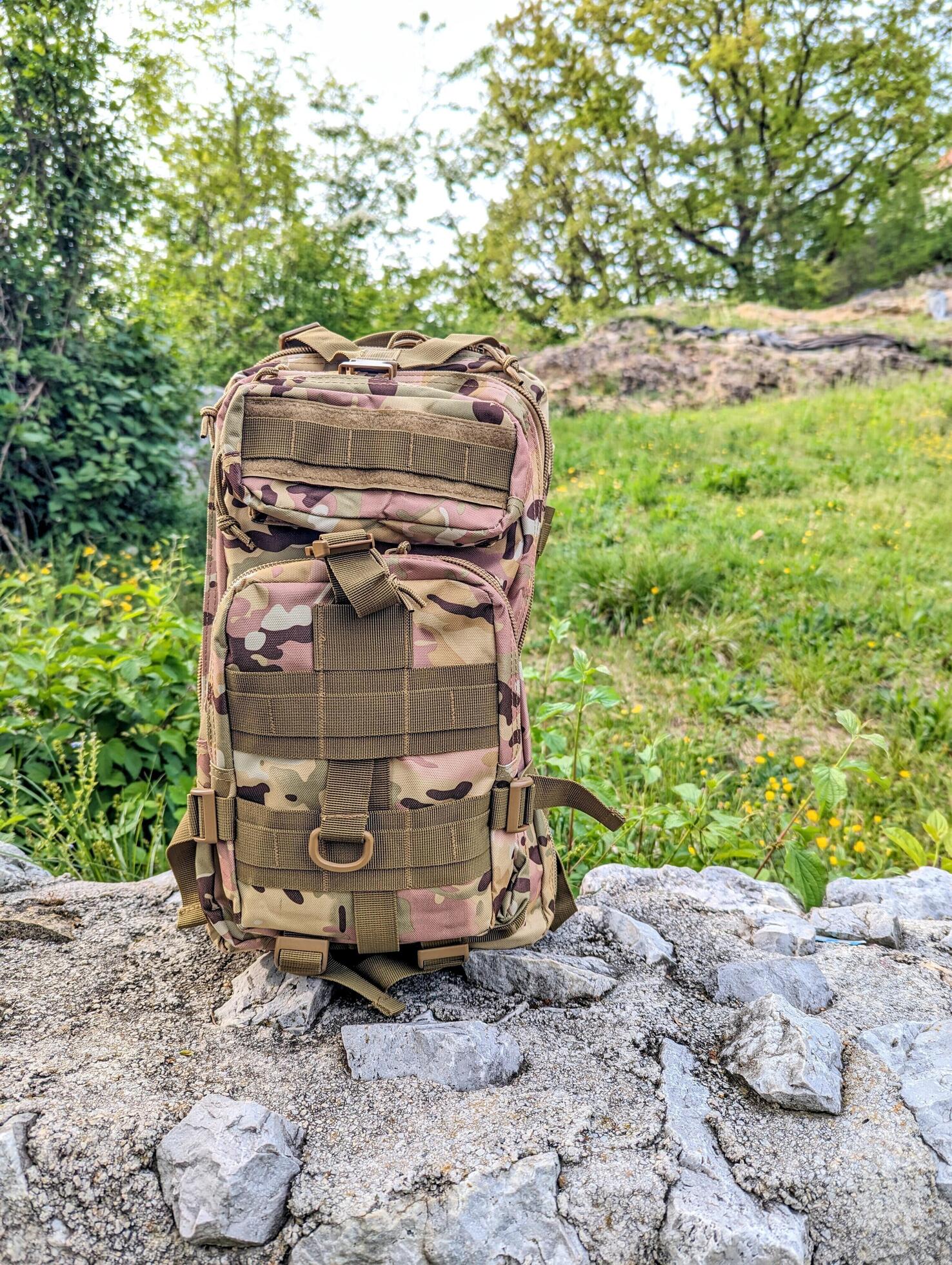 army military backpack, camo bag, hiking gear and accessories, nature background Stock Free