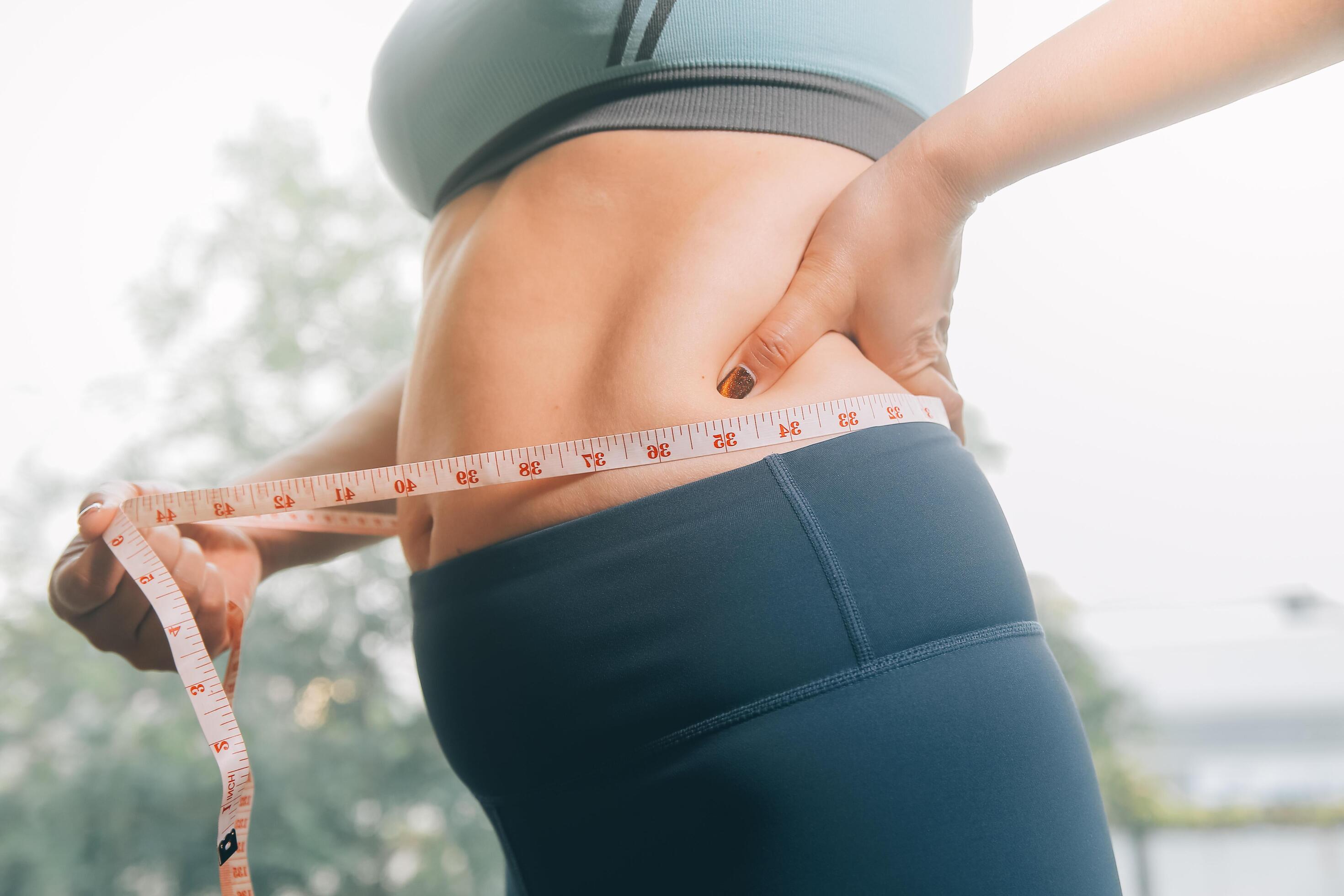 fat woman, fat belly, chubby, obese woman hand holding excessive belly fat with measure tape, woman diet lifestyle concept Stock Free