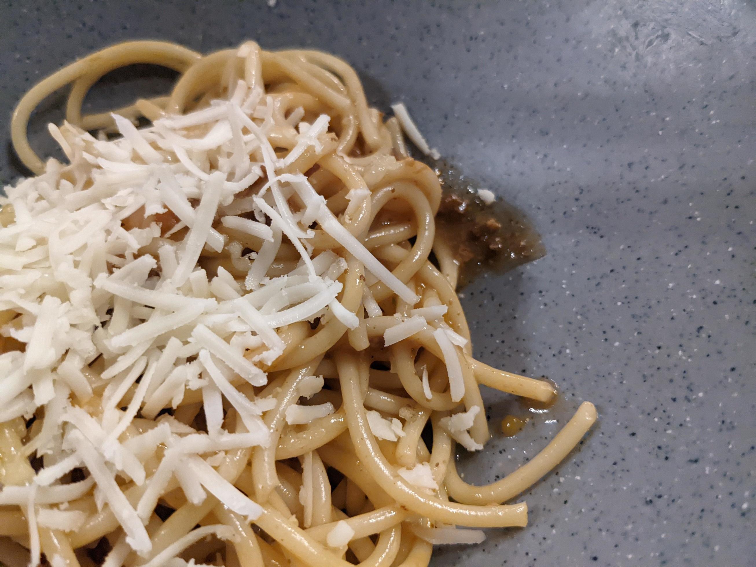 Spaghettis Bolognese with cheese cheddar topping on the grey bowl. The photo is suitable to use for food background, poster and food content. Stock Free