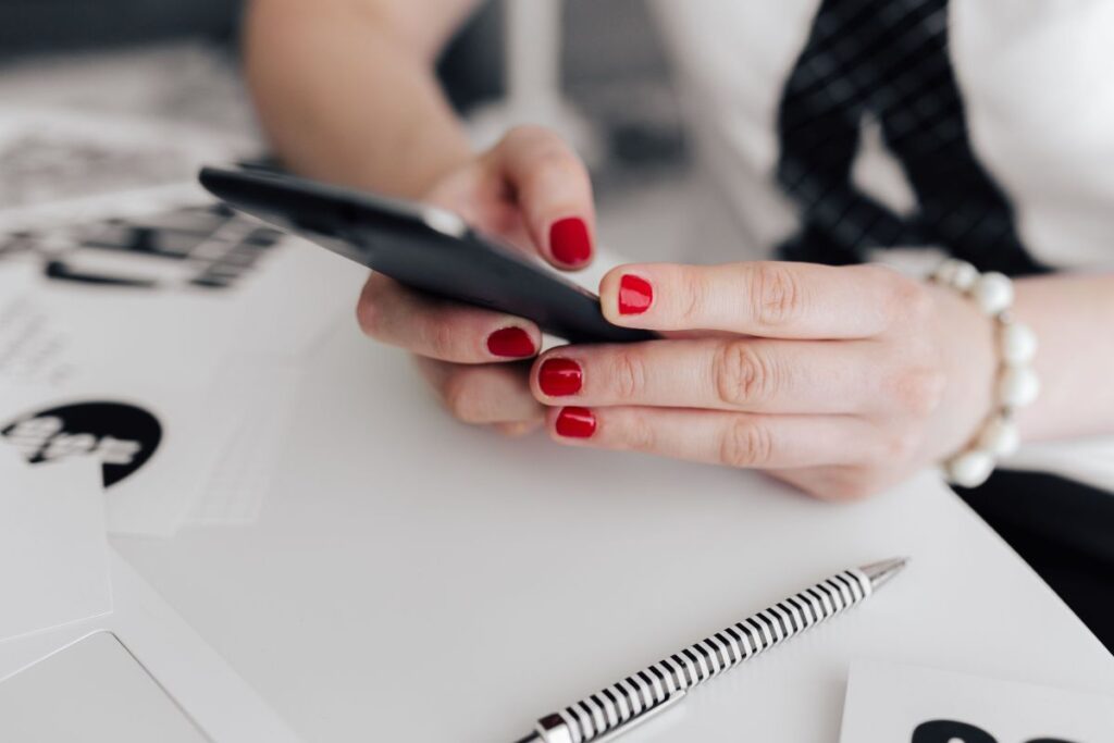 Businesswoman uses her mobile phone at her desk Stock Free