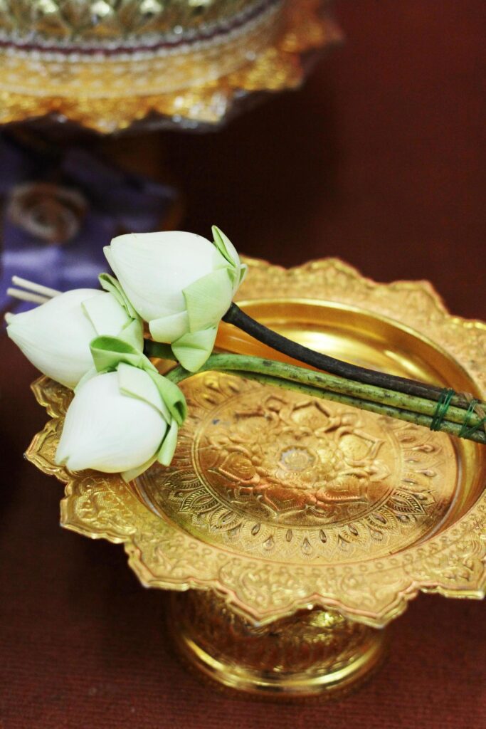 Beautiful pink lily and lotus flowers decoration on gold tray for pray Buddha statue.Thai wedding culture tradition. Stock Free