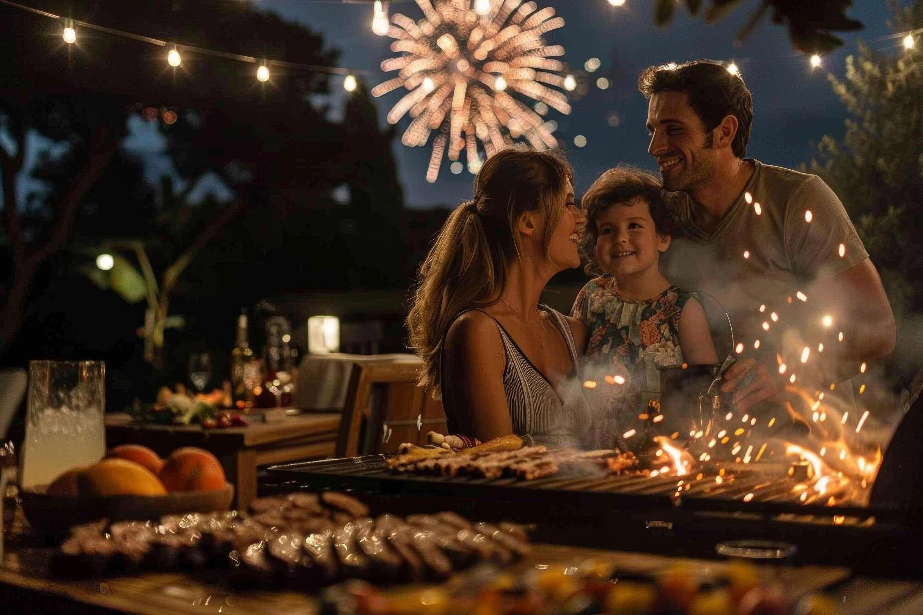 
									A family enjoying a barbecue in their backyard with fireworks in the background Stock Free