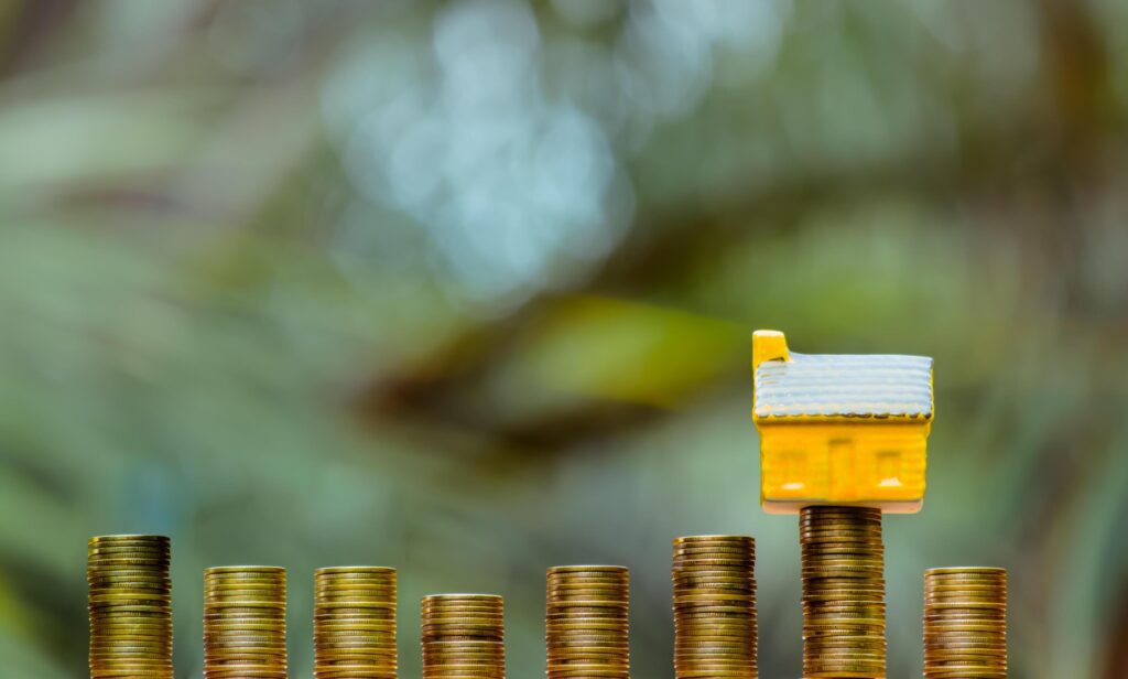 House model and coins money, Business Finance coin stack growing graph with green tree bokeh background,investment, loans and real estate concept Stock Free