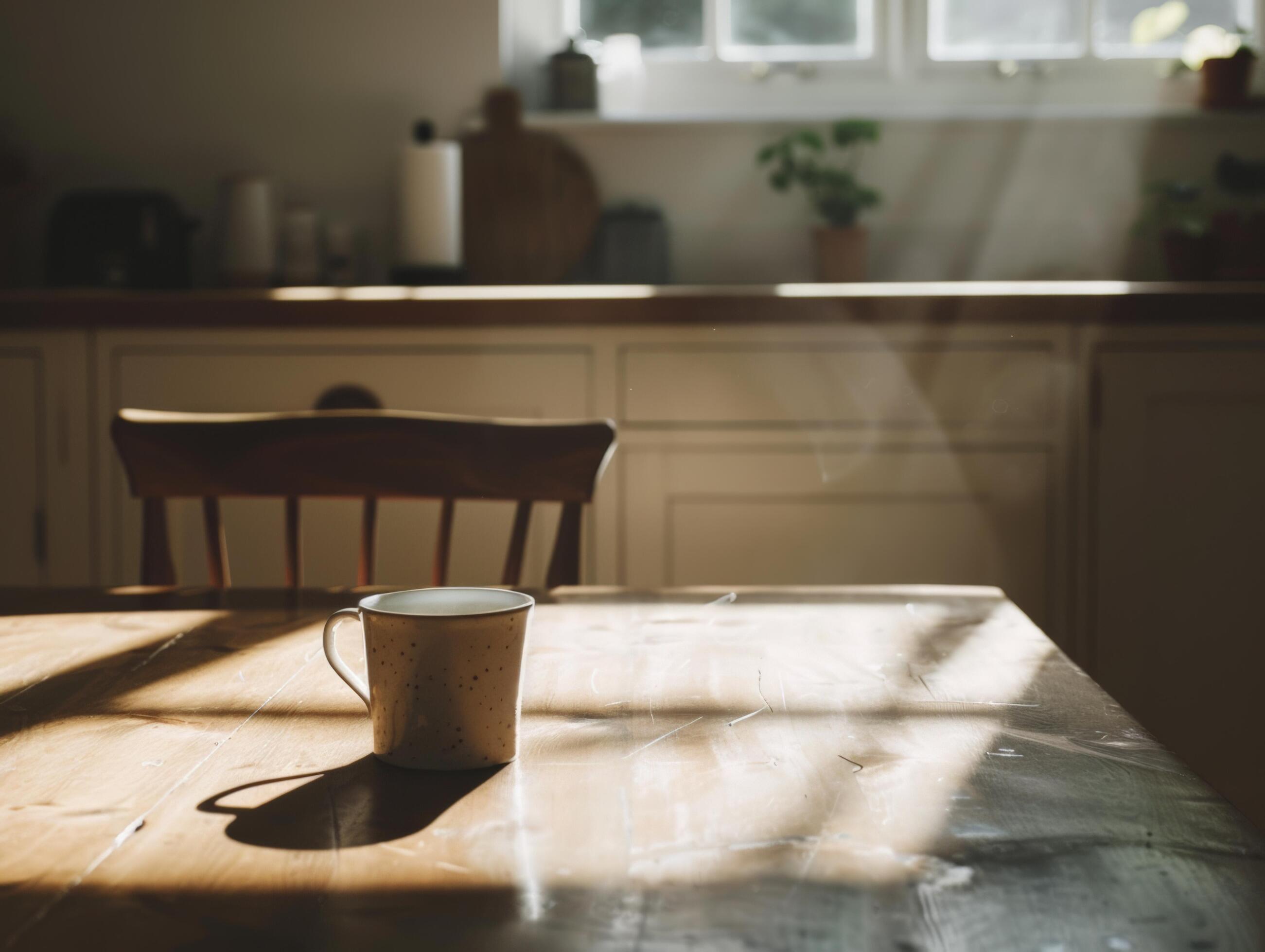 Sunlit kitchen featuring a wooden table with a coffee cup, natural light and cozy atmosphere, home and lifestyle concepts Stock Free