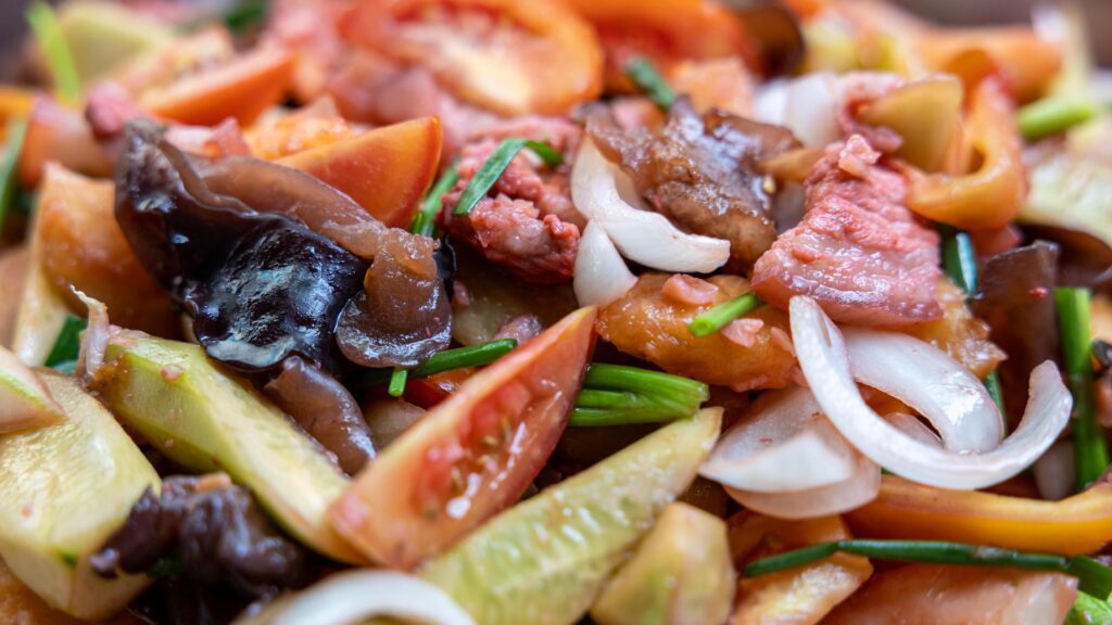 Close-up view of the background of sweet and sour stir-fry, consisting of pork pieces. Stock Free