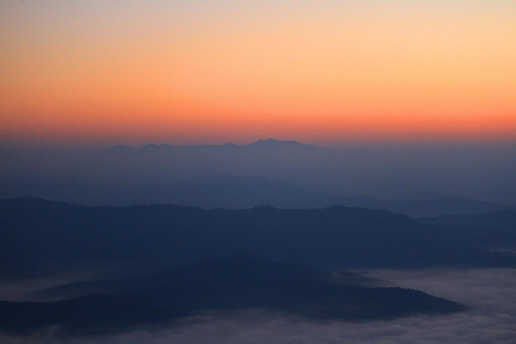 Beautiful golden natural sunlight and twiligh of sunrise shining to in the mist on valley of mountain in Thailand Stock Free