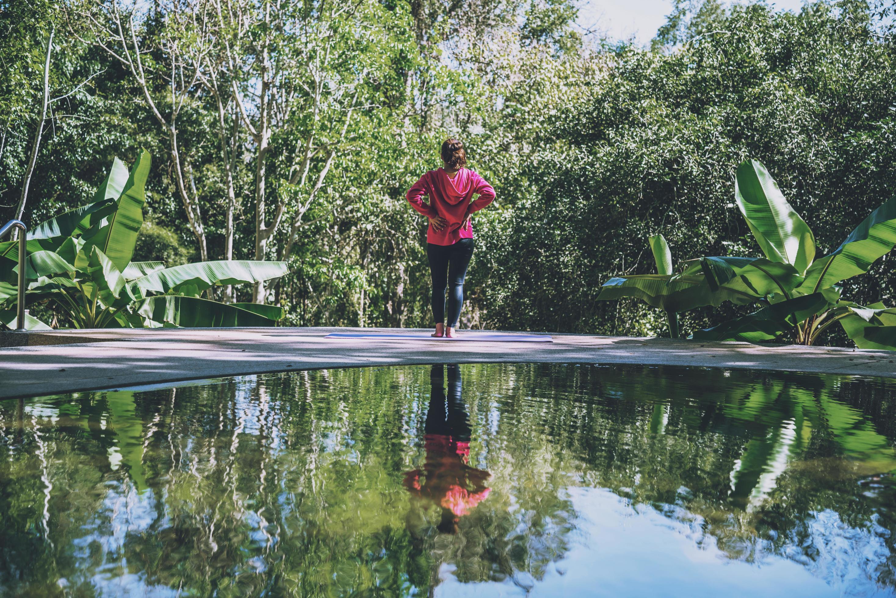 Young girl standing relaxing body, yoga exercise. Hot Springs In National Park,Hot Spring nature travel,Relax and exercise at the pool. Stock Free