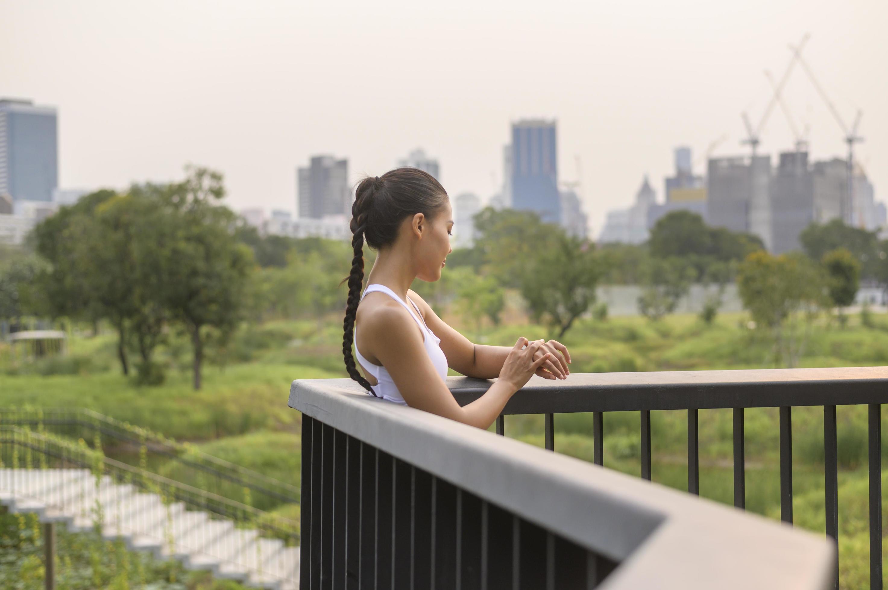 A young fitness woman in sportswear using smart watch while exercising in city park, Healthy and Lifestyles. Stock Free