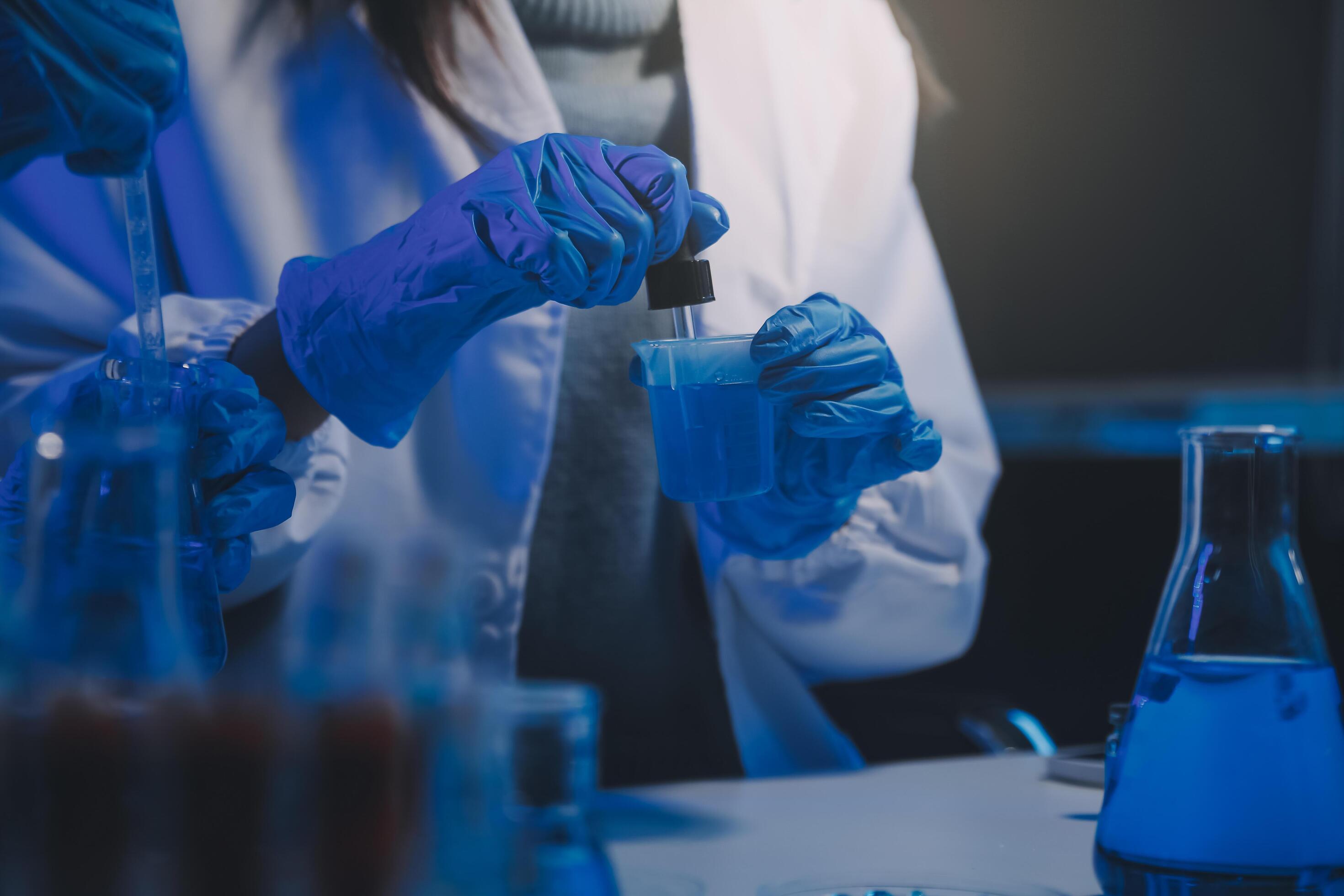 chemist,scientist hand dropping chemical liquid into test tube, science research and development concept Stock Free