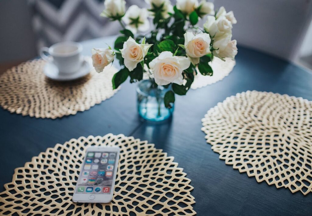 Round breakfast table with white flowers and golden coffee mats Stock Free