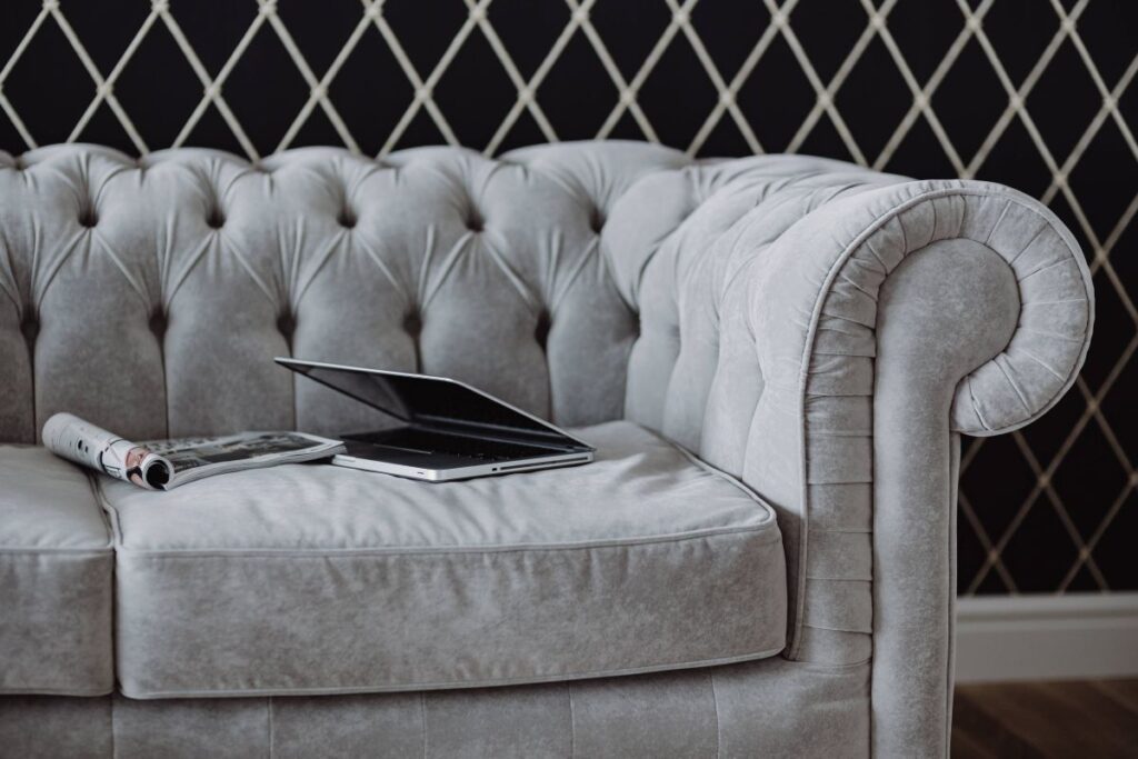 Elegant grey sofa with a laptop, an iPhone and a magazine Stock Free