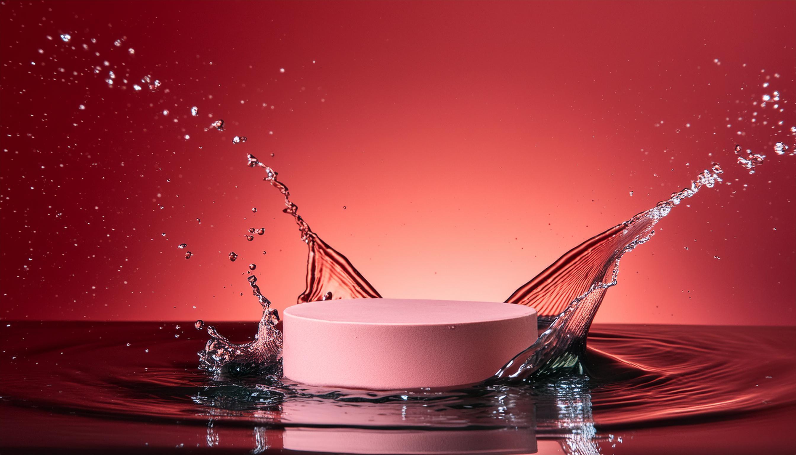 empty pink podium mockup with water splash on a red gradient background for product display Stock Free