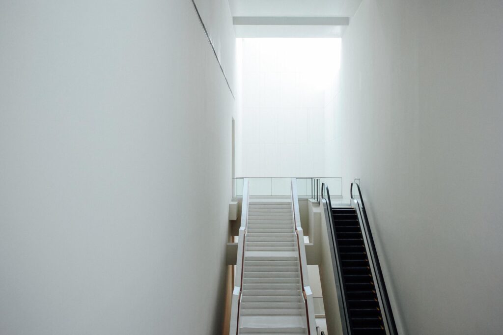 New modern escalator and stairways in minimal white building interior Stock Free